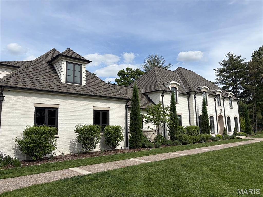 This exceptional home is truly a showstopper! Nestled on nearly 2 private acres, it offers a serene setting with a lush, expansive lawn and a resort-style backyard designed for effortless entertaining or relaxation. Enjoy the in-ground pool alongside multiple outdoor living spaces, including a spacious patio, a covered lounge complete with heaters, fans, television, and fireplace, and a fully equipped covered outdoor kitchen.

Step inside and be immediately captivated by the abundance of natural light, soaring ceilings, striking black-framed windows, and hardwood floors—all complemented by a sophisticated neutral palette. The main level features a formal dining room, a private office or bonus room, and an elevated wet bar area with sleek black cabinetry, two wine refrigerators, and dual French doors that open seamlessly to the poolside patio—perfect for expanding your entertainment space.

The gourmet kitchen is a standout, showcasing white marble countertops, a custom black refrigerator, double Wolf ovens, a gas range, and a stunning copper kitchen sink. It flows effortlessly into the oversized family room, highlighted by a beautiful mantle and vaulted, beam-accented ceilings.

The main-floor primary suite offers a luxurious retreat with a spa-like bathroom featuring an oversized walk-in shower, freestanding soaking tub, dual vanities, and spacious walk-in closets. Additional conveniences on the main level include two half baths, a walk-in pantry, and a well-appointed laundry/mudroom with built-in cubbies and direct garage access. Above the garage, you’ll find a private en-suite bedroom with a full bath—ideal for guests.

Upstairs, three generously sized en-suite bedrooms each feature walk-in closets and plantation shutters, along with a second laundry room for added convenience.

The lower level continues to impress with a large, mostly finished space that includes a fifth bedroom and full bathroom, cozy carpeting, high ceilings, and daylight windows, along with ample unfinished storage space.

Combining timeless design with modern convenience, this home offers the perfect balance of privacy and accessibility—tucked away in a quiet cul-de-sac while remaining walkable to Palm Health and Clayprice Shopping Center which is home to Kaldis Coffee, Butchery Market, Truffles and more!