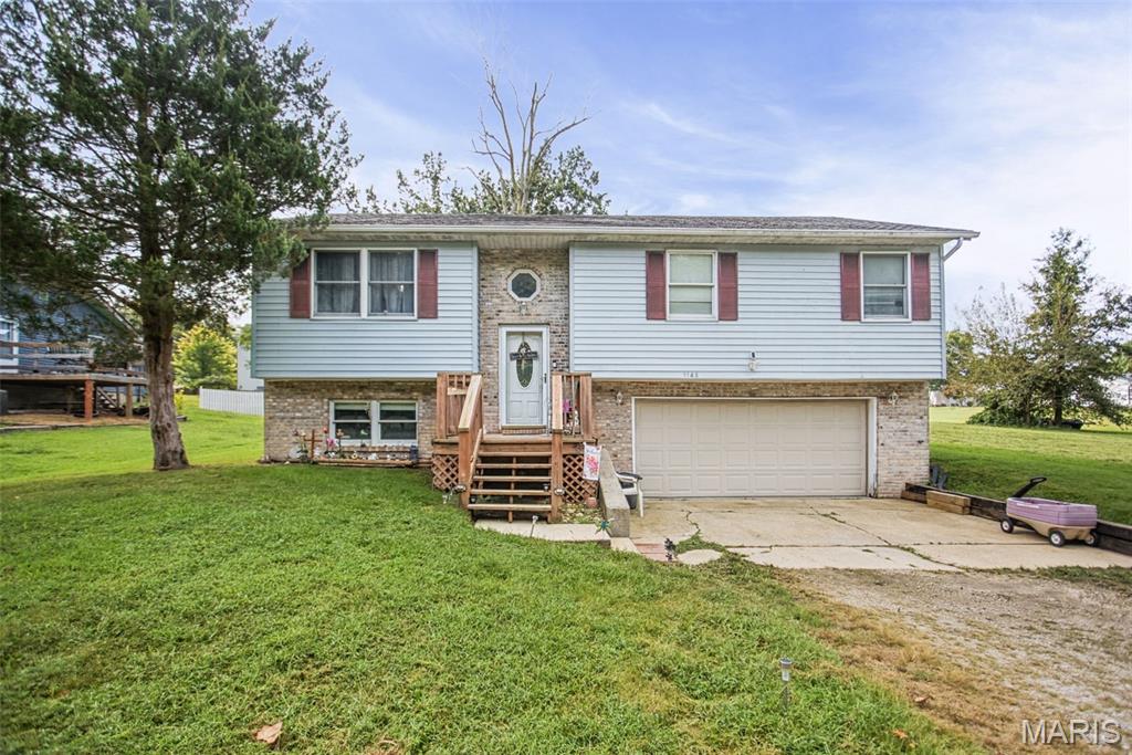 Welcome to Holiday Shores! This inviting split-foyer home offers 3 bedrooms and 3 full bathrooms in a desirable lake community. The main level features a comfortable living room and eat-in kitchen, while the finished lower level provides additional versatile living space with a full bathroom, which is ideal for guests, entertaining, a home office, or recreation space. Step outside to the back deck and enjoy the peaceful setting, located just up the hill from the lake. An oversized 28x23 garage provides plenty of room for vehicles, storage, and recreational equipment. Enjoy the relaxed lake lifestyle and amenities that make Holiday Shores such a sought-after place to call home.