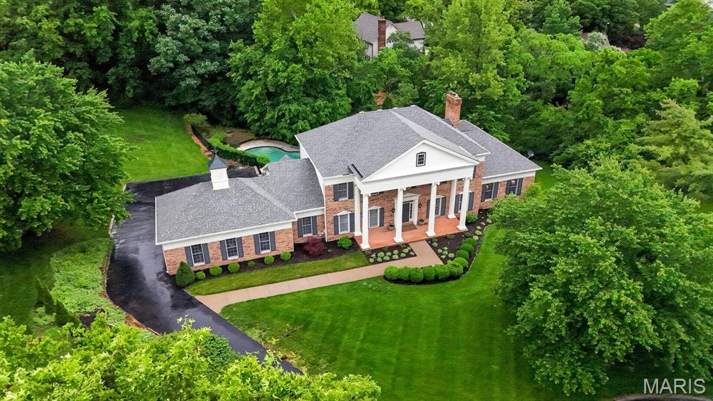 Don’t miss the opportunity to own this beautifully maintained Miceli-built home, perfectly positioned on a lush 1-acre lot in prestigious Essex Point in Town and Country. Offering over 5,900 square feet of thoughtfully designed living space, this home blends timeless craftsmanship with a fresh, updated feel throughout. The heart of the home is a light-filled custom kitchen and a spacious family room with fireplace and wet bar—ideal for both everyday living and effortless entertaining. A four-season sunroom overlooks the private backyard and sparkling pool, enhancing the home’s indoor-outdoor lifestyle. Step outside to the new deck (2026), providing the perfect setting for gatherings, dining, or simply enjoying the serene surroundings. The main level also features elegant dining and living rooms, a private primary suite with adjoining office, gleaming hardwood floors, powder room, and laundry. Upstairs, you’ll find three generously sized bedrooms, two full baths, and a versatile office or bonus space. The finished lower level adds incredible flexibility with a second family room and fireplace, bar area, guest suite with full bath (ideal for poolside convenience), abundant storage, and direct walkout access to the expansive pool deck and backyard. An oversized 3-car garage completes this exceptional offering. Experience a refined yet relaxed lifestyle in one of Town and Country’s most sought-after neighborhoods.