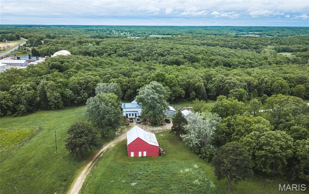 This versatile and well-rounded property offers the perfect blend of recreation, hunting, and country living, all in a highly accessible location. At the heart of the farm is a beautiful 3.5-acre stocked pond, complete with a boat dock and managed for quality fishing—home to trophy largemouth bass pushing 8 pounds. The fishery has been carefully maintained over the years with supplemental feeding, creating an exceptional private fishing experience. The land is equally suited for outdoor enthusiasts, featuring a dedicated shooting range ideal for target practice and sighting in rifles or bows ahead of the season. A wet-weather creek winds through the property, adding to the natural appeal, while established trails provide easy access throughout for ATVs or quiet walks in the woods. Behind the farmhouse, you’ll find a charming orchard with apple, apricot, and cherry trees, offering both beauty and productivity. Approximately 9 acres of open pasture provide space for livestock, hay production, or future improvements, complemented by a nice stand of timber that holds abundant deer and turkey. Five new deer stands are already in place, making this a turnkey hunting setup. The 2,120-square-foot farmhouse offers 4 bedrooms and 1 bath, with updates already completed on the main level. Whether you appreciate the character of an older farmhouse or are looking for a comfortable weekend retreat, this home provides a solid foundation with plenty of potential. Additional improvements include a hay barn with lower-level storage, a storage shed, and a tool shed—offering ample space for equipment, ATVs, and farm essentials. A well-maintained gravel road with 2-inch clean rock ensures easy access throughout the property. With highway frontage on two sides along Highway 50, this property offers excellent accessibility and future potential, whether for subdividing or creating additional access points. Conveniently located just 15 minutes from Owensville, about an hour to Jefferson City, and within 45 minutes of Union and Washington, you get the perfect balance of privacy and proximity. If you're looking for a property that checks all the boxes—fishing, hunting, recreation, and country living—this one delivers.