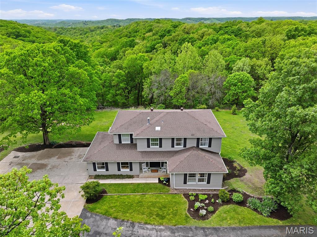 Don’t miss this exceptional Wildwood home, gracefully set on 3 private acres with breathtaking scenic views and a retreat-like setting. Equestrian-friendly—horses are welcome!!
The spacious entry foyer welcomes you with bamboo flooring that extends throughout the main level, complementing the home’s inviting and functional floor plan. The  living and dining rooms flow seamlessly into the open-concept kitchen and family room, where French doors fill the space with natural light and provide effortless access to the expansive deck—perfect for indoor-outdoor living and entertaining.
The kitchen is thoughtfully designed and beautifully appointed with stainless steel appliances,  granite countertops, 42-inch cabinetry, and an dreamy walk-in pantry.
Upstairs, you’ll find 4 generously sized bedrooms, along with a convenient second-floor laundry that can easily be converted back into a 5th bedroom if desired. The spacious primary suite features a walk-in closet and a well-appointed en-suite bath.
The walkout, partially finished lower level offers a recreation room, wet bar, and bonus room—ideal for additional living, entertaining, or flexible use.
Outdoors, the property truly shines as a private retreat, featuring a garden area, tasteful landscaping, and a fire pit perfect for gathering and creating lasting memories. The fully fenced grounds provide ample space for recreation, pets, and horses. New septic installed July 2020