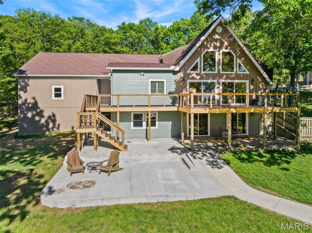 This large lakefront home with nearly flat lakefront yard, acreage, substantial garage/shop space, and no HOA or restrictions. With approx. 5,415 sqft, 5 beds, 4 baths, 3.39 acres, approx. 100 ft of lakefront, a large attached garage, and an approx. 2,326 sq ft detached shop, this property is well-suited for buyers needing room for vehicles, lake toys, equipment, business use, hobbies, guests, or multi-purpose living. The home offers open main-level living leading to a new composite deck. There's also a nearly 600sqft room perfect for gym or bunk room. The massive upper primary wing includes dual vanities, tile shower, walk-in closets, and private HVAC. A separate upper level features two additional bed/bunk rooms with walk-in closets. Even more living space in walk-out with a bed, a bath, a storm/safe room, and a rough-in for a future wet bar. An impressive & efficient masterpiece with extensive insulation, 400amp underground, 5 HVAC systems, private well, Gravois sewer, newer mechanicals, dock, and quick access to lakefront destinations make this a highly livable and VRBO-able, Lake of the Ozarks property. Check out the feature sheet to see all that this property has to offer.