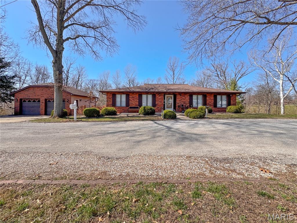 This beautifully maintained 3-bed, 3-bath ranch offers nearly 3,000 finished square feet, a walkout lower level, and a second full kitchen, creating a flexible and inviting home that adapts effortlessly to your lifestyle. A formal foyer opens to pristine hardwood floors and a warm, neutral palette that flows into the spacious living room, where double picture windows fill the space with natural light and a white-mantled fireplace adds charm and ambiance for those classic Norman Rockwell evenings. An oversized doorway leads to the priate dining room with wood floors, updated lighting, chair rail, and French doors that open to an oversized composite deck overlooking a private wooded view and a tidy garden shed. A great place to hang out for game night or enjoy your favorit jigsaw puzzle  The self-contained, all-electric eat-in kitchen offers the perfect amount of space for cooking without distraction, with ceramic floors that make cleanup easy. A recently remodeled hall bath features a step-in shower, comfort-height vanity with solid-surface top, abundant storage, and a walk-in closet. The primary bedroom includes sculptured carpet, neutral paint, private deck access, a large walk-in closet, and a convenient half bath, while the second main-level bedroom is bright and nicely sized. A chair lift provides smooth access to the lower level (but could be easily removed), where zoned HVAC with a Trane furnace ensures year-round comfort. A small sitting room with LVP flooring and storage sits just off the landing. The third bedroom on the lower level includes a full egress window and a 36" doorway, and the laundry room with washer and dryer included offers a walkout door to the professionally landscaped patio with pavers. The expansive family room—complete with a full second kitchen and charming brick accent wall—will quickly become the heart of gatherings, with French doors opening to a fully covered patio that makes it easy to grab firewood for the custom fireplace. A full bathroom with ceramic tile and a tub/shower combo is conveniently located nearby. The lower-level kitchen includes a pass-through window, breakfast area with pantry, vinyl flooring, electric oven, refrigerator, tile backsplash, and laminate counters, blending just a hint of vintage charm with everyday practicality—somewhere between your favorite coffee shop and grandma’s kitchen. This home could accomodate  the need for separate living spaces.  Additional highlights include new insulation, an oversized two-car garage, a private wooded view, low-maintenance outdoor space, and a quiet private street. Thoughtfully updated and lovingly cared for, this home is an absolute charmer from top to bottom and ready for its next owner to enjoy immediately.  See listing information sheet with disclosures for additional information.