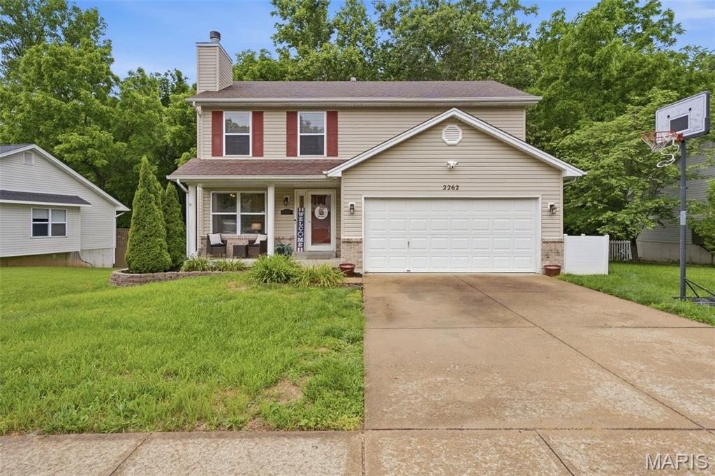 Welcome to 2262 Castlegate Drive in Imperial, Missouri. This spacious two-story home offers 4 bedrooms, 4 bathrooms, a finished basement, attached 2-car garage, and a fully fenced backyard backing to mature woods for exceptional privacy.

The main level features hardwood flooring, crown molding, a brick wood-burning fireplace, and an open-concept layout ideal for everyday living and entertaining. The kitchen showcases custom forest-green cabinetry, stainless steel appliances including a gas range and French door refrigerator, tile flooring, pendant lighting, and direct access to the elevated deck overlooking the wooded backyard.

Upstairs, you'll find generously sized bedrooms and multiple full bathrooms designed to accommodate busy households. The finished lower level provides flexible space for a recreation room, media room, home gym, office, or play area.

Outdoor living shines with a raised deck, white vinyl privacy fence, storage shed, play area, and a flat backyard that offers room to relax, entertain, or enjoy nature. A unique bonus is the attached garage currently configured as a golf simulator space, providing year-round enjoyment for golf enthusiasts.

Conveniently located in the Castlegate subdivision near Highway 55, shopping, dining, schools, parks, and recreation, this home offers the space, flexibility, and privacy today's buyers are searching for in Imperial, Missouri.