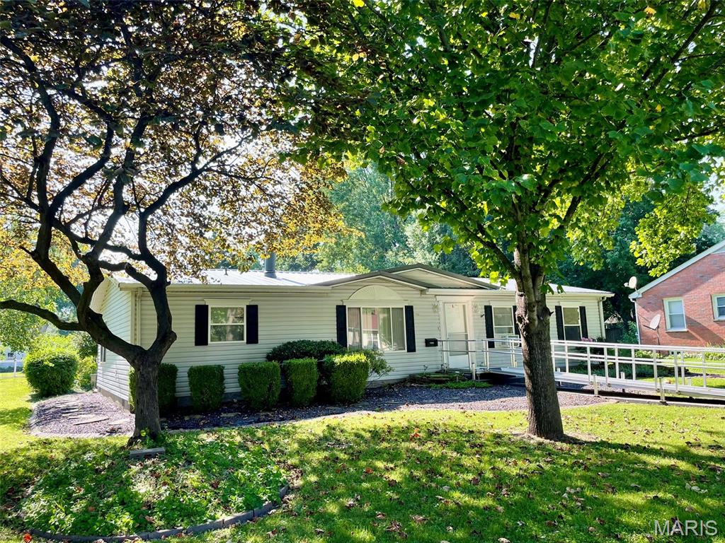Beautifully landscaped and full of charm, this well maintained 3 bedroom, 2 bath home offers comfort, convenience, and versatile living spaces on a generous .4 +/- acre lot. An accessible front ramp provides easy entry. The spacious living and dining areas flow seamlessly together, creating a welcoming setting for everyday living and entertaining. Fireplace is framed with cabinetry and shelves. The kitchen features a center island, skylight, and a cozy breakfast nook. Included with the home are gas range, microwave, dishwasher, washer, dryer, and two refrigerators. Primary suite features a garden tub. Two hall closets add additional storage space. One bedroom has built-in shelving.  Step outside to the covered concrete patio - an ideal spot to relax, entertain guests, or enjoy your morning coffee while overlooking the attractive landscaping. The oversized two-car garage, accessible from the alley, includes a heated and air conditioned bonus room that is perfect for hobbies, a workshop, craft room, or home office. Bonus garden shed provides plenty of space for gardening supplies and outdoor tools.