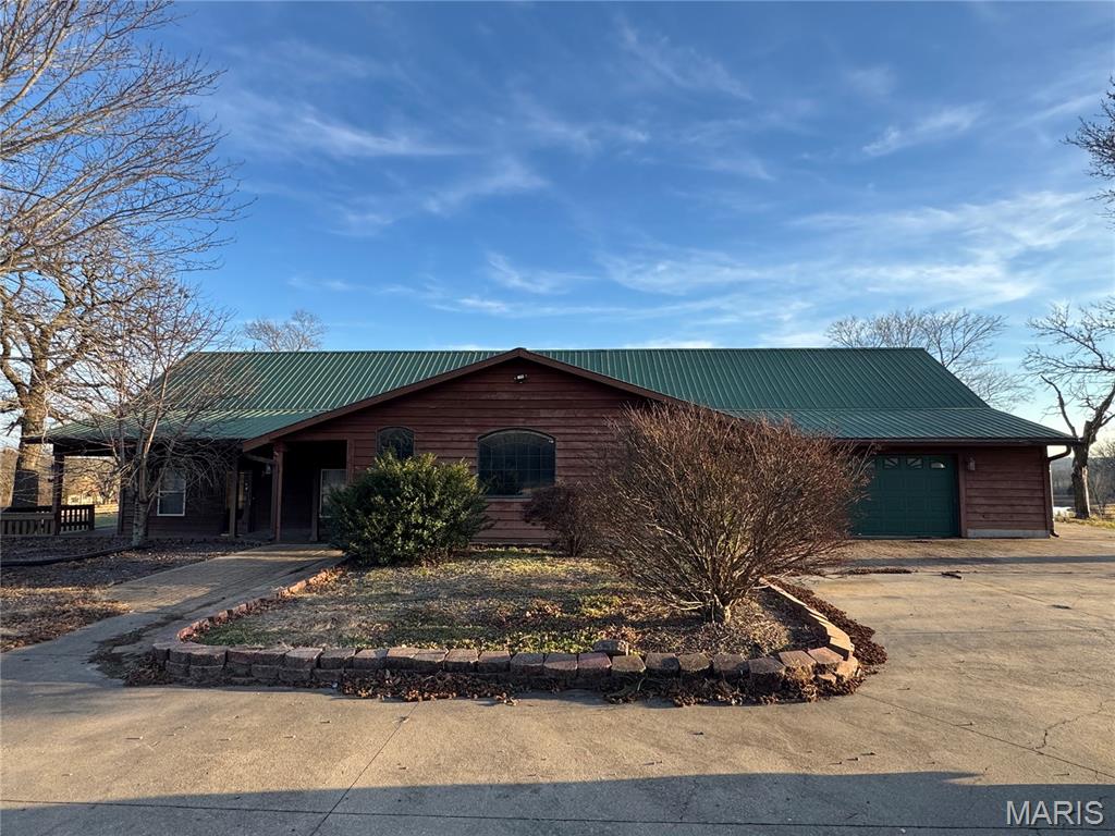 Spacious Rustic Home on 5 Acres With Stunning Views!  Just 2 miles from town on paved roads, this one-of-a-kind property offers plenty of room. Featuring 5 bedrooms and 3 bathrooms, the home welcomes you with a large vaulted great room complete with a fireplace, and a vaulted primary suite with generous walk-in closets. The expansive kitchen includes stainless steel appliances, custom cabinetry with lighting and detailed millwork, granite countertops, and a breakfast bar—perfect for gatherings. Step outside to the covered deck overlooking your private inground pool, extensive concrete patio space, and beautiful long-range views. The lower level provides even more room to entertain with a private bar, recreation area, and additional storage. An attached garage plus a detached garage offer ample parking and workspace.  Updates have been made in recent years, but additional repairs and improvements are still needed. Home is being sold as-is. With incredible space, land, and features, this property offers outstanding potential to customize and build equity.