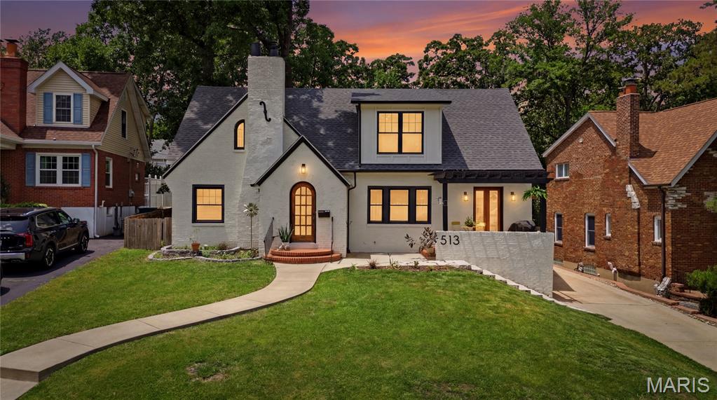 Located on one of Webster Groves' most coveted streets, this thoughtfully reimagined Tudor offers close to 3,000 square feet of living space, blending timeless character with modern updates and functionality. Extensively renovated in 2022, the home beautifully balances historic charm with today's lifestyle. A pergola-covered front patio creates a welcoming outdoor retreat overlooking iconic Hollywood Place, while the arched entry preserves the home's architectural character. The heart of the home is the expansive open-concept kitchen, dining, and living area designed for everyday living and entertaining. The kitchen features a large center island and opens seamlessly to the gathering spaces. Just off the kitchen, a versatile walk-in coffee bar and prep pantry adds both charm and functionality with additional storage, workspace, and room for small appliances. A built-in bench provides additional storage and everyday convenience. A rare main-floor primary suite offers a private retreat with custom built-ins by St. Louis Closet Company, a spacious walk-in closet, and a beautifully updated bath complete with a soaking tub, walk-in shower, and double vanities. The enclosed rear porch serves as a bright mudroom-style entry from the detached garage and backyard, complete with a nearby powder room for added convenience. Upstairs, you'll find a versatile loft area ideal for a playroom, study space, music room, lounge, or second family room, a full bath with double vanities, three additional bedrooms with generous closet space, and a dedicated office featuring a stackable laundry option. Additional laundry hookups are also located in the unfinished portion of the lower level. The lower level offers a partially finished recreation area along with abundant storage space. Outside, enjoy a large backyard, stamped concrete patio, detached garage, and multiple spaces to relax and entertain. Combining historic Webster charm, flexible living spaces, and thoughtful updates throughout, this is a rare opportunity to own a thoughtfully updated home on one of the community's most desirable streets.