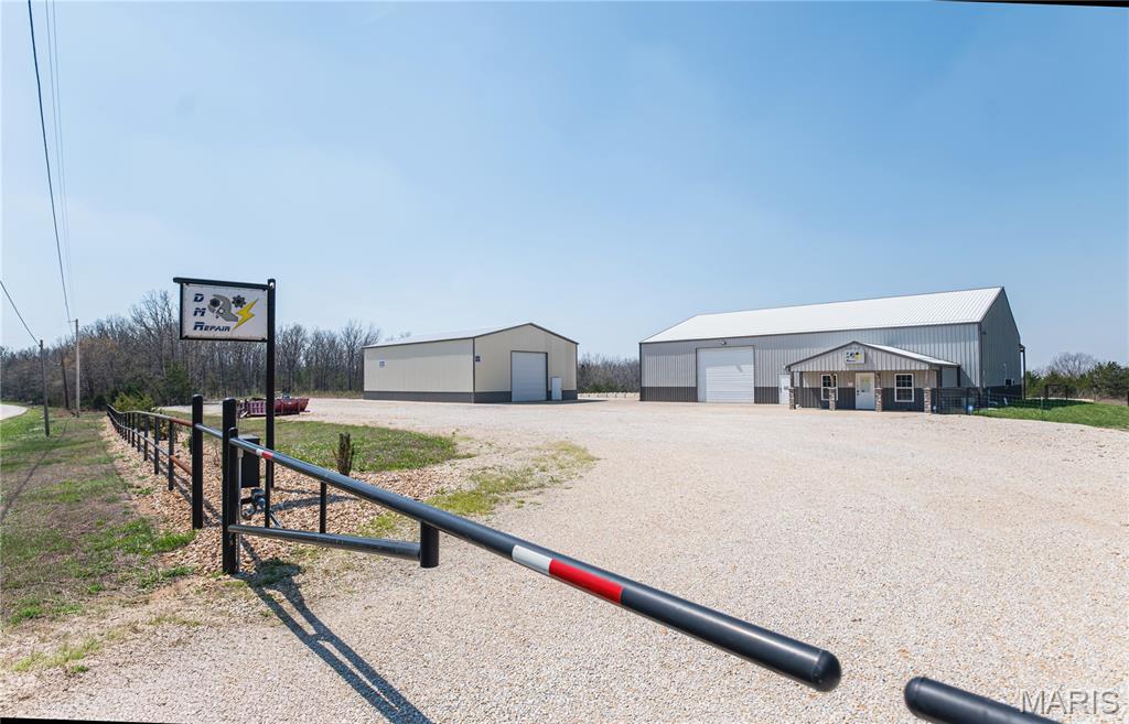 Cut the commute to zero! Built for entrepreneurs, makers, and dreamers - seize this incredible business opportunity just outside of Rolla! Situated on 4 scenic acres, this versatile commercial property is built for growth, functionality, and endless potential. The primary 60x80 building offers a thoughtfully designed setup with welcoming office space right inside the front entrance, along with a full bathroom featuring a standing shower. The shop area is fully climate-controlled with both heating and air conditioning, creating a comfortable workspace year-round. Built on a heavy-duty concrete foundation, the space is ideal for operating machinery, accommodating large vehicles, or supporting a variety of industrial uses. Additional highlights include a dedicated paint bay with ventilation system, a concrete loading dock along the south wall, and a covered, full concrete lean-to extending off the back. A second 40x60 building provides even more flexibility, complete with an electric overhead drive-in door—perfect for additional storage, workspace, or equipment housing. The property also features approximately 2 acres of leveled, gravel-covered ground, ideal for parking semi-trucks, trailers, or fleet vehicles. Located along a major carrier route, this property offers both accessibility and visibility for your business operations. Whether you're expanding an existing operation or starting something new, this property delivers the space, infrastructure, and location to make it happen. Schedule your private showing today! Ask for building asset list from installs over the years. There are also 40+ additional acres available for sale - ask your agent for more info!