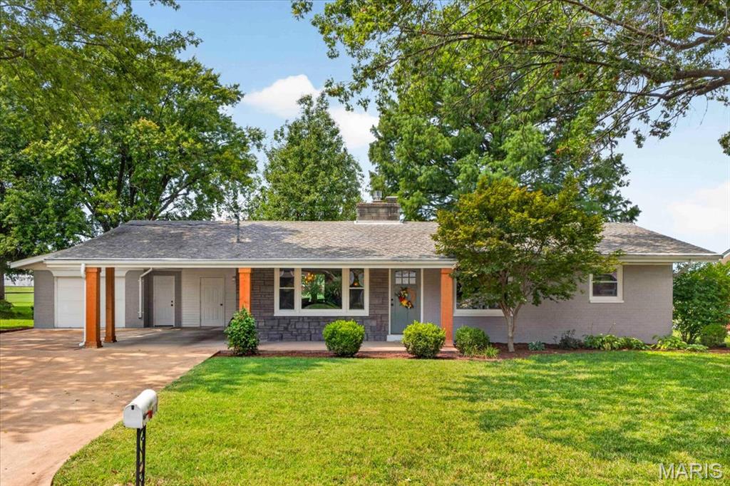 Completely remodeled ranch home on a third-acre side lot in Waterloo's District 5, offering extra yard space and backing directly to the school track and baseball diamond. Enjoy wide-open green space with no rear neighbors. A covered front porch with stone and wood accents welcomes you inside to an open, light-filled living room anchored by a striking gray-painted brick fireplace and wide-plank flooring throughout the main level. The fully renovated kitchen is the showstopper, featuring slate-blue cabinetry, solid surface countertops, a full stainless steel appliance suite with gas range, built-in wine fridge, floating shelves, and stylish hexagon tile backsplash. A custom built-in banquette anchors the adjoining dining nook beneath a statement pendant chandelier-perfect for everyday meals or entertaining. Two bedrooms and a full bath complete the main level, with the bath showcasing a tiled shower, sleek vanity, and modern updates. The full basement adds serious bonus living space, including a spacious non-conforming bedroom with its own brick fireplace, a second full bathroom, and a large open area currently set up as a home office and media/game room-ideal for a guest suite, recreation room, or teen hangout. Outside, you'll find a one-car oversized garage with a storage closet, stamped concrete patio, and spacious tree-shaded yard with plenty of room to roam. All just steps from the ballfields, track, and tennis courts, with easy access to Waterloo's schools, shops, and dining. This move-in-ready ranch delivers the space and flexibility of a much larger home with the ease of single-level living. Schedule your showing today!