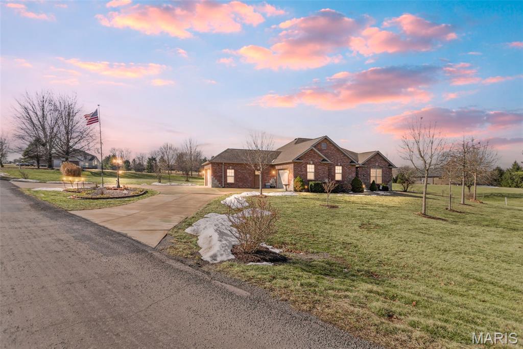 Custom-built brick ranch with stone accents on 2.2 acres in a quiet subdivision, offering over 3,000 sq ft of finished living space. This elegant home features an open-concept design with hand-scraped solid oak flooring, crown molding, and quality fixtures throughout. The living room showcases a direct-vent gas fireplace, while the chef’s kitchen includes solid surface countertops, stainless appliances, beverage cooler, pantry, and large island with bar seating. The primary suite offers a walk-in closet and spa-like bath with double vanity and separate shower. Main-level laundry adds convenience. The recently finished lower level provides approximately 1,100 sq ft with a spacious family room, additional bedroom, and full bath—ideal for guests or extended living. Enjoy peaceful views from the screened-in porch overlooking beautifully landscaped grounds. Additional highlights include an oversized garage, circular drive, workshop/storage space, and mature trees. Luxury, privacy, and space combine in this exceptional property.