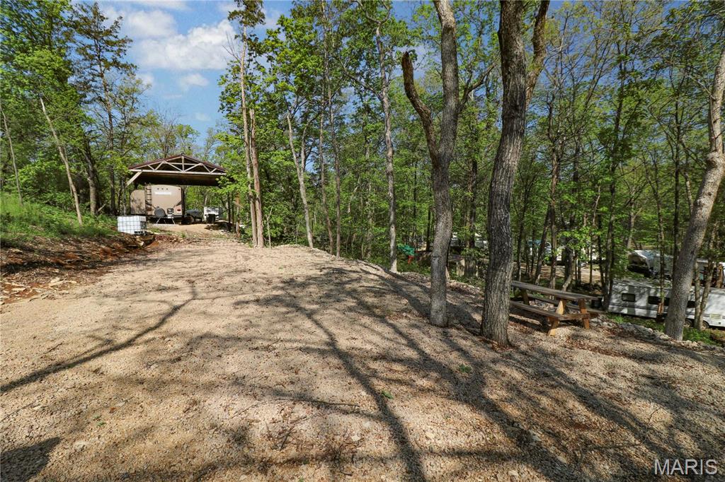 Looking for recreational property? Opportunity to own 4 corner lots in beautiful Cedar Lake where you can camp, fish, kayak, swim and enjoy the outdoors.  Vacation property is partially graded and ready for your RV including a camper electric box and freshwater tank. Cedar lake is a private gated community located approximately one hour south of St. Louis. Create your own outdoor oasis!
