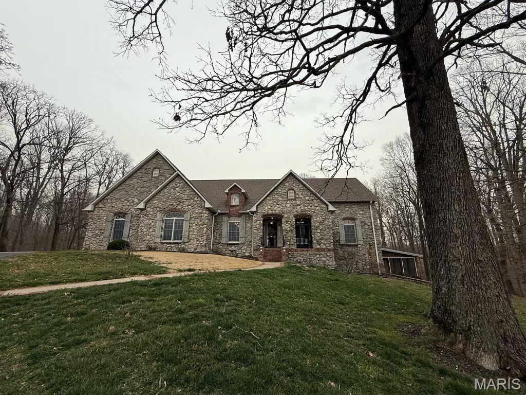 Experience timeless elegance and serene country living on this stunning 29-acre estate. This beautiful French Country stone ranch offers 5 spacious bedrooms, 3.5 baths, and an inviting open layout perfect for entertaining. The heart of the home is a large sun porch overlooking a 20x40 in-ground pool, with sweeping views of rolling timber, a private 3.5-acre pond, and picturesque countryside. Enjoy the comfort and efficiency of geothermal heating and cooling, and ample space with a 4-car garage. A gated entrance and classic white fencing complete the sense of privacy and sophistication. Whether relaxing by the pool, fishing in your private pond, or taking in the breathtaking scenery, this property is a true retreat.