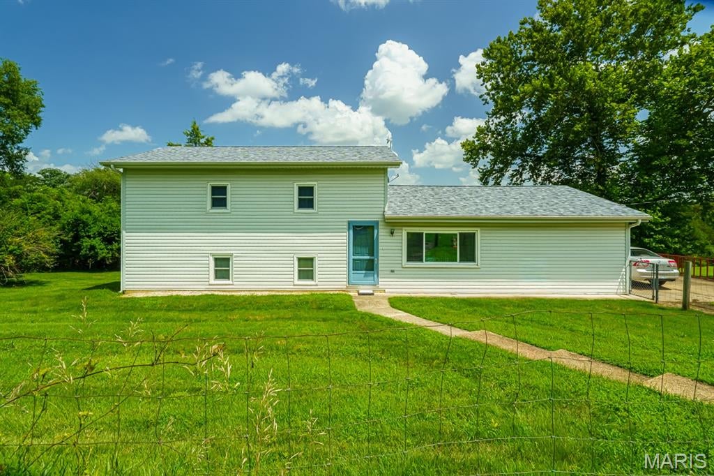 Enjoy country living with the convenience of being just minutes from the city limits! This 3-bedroom, 2-bath split-level home sits on 2 acres along a quiet county road and offers plenty of space inside and out. Features include a spacious kitchen with abundant cabinet storage, dedicated dining area, and a versatile utility room perfect for storage, hobbies, or entertaining. Upstairs you'll find all three bedrooms, including the primary suite, with generous closet space throughout. The lower level offers newer carpet, a family room, office/flex space, ample storage, and walkout access to the backyard. A fenced area around the home provides added convenience, while the open acreage offers endless possibilities. Shingles were replaced in 2024. Property is being sold AS IS. Great location, great home—schedule your showing today!