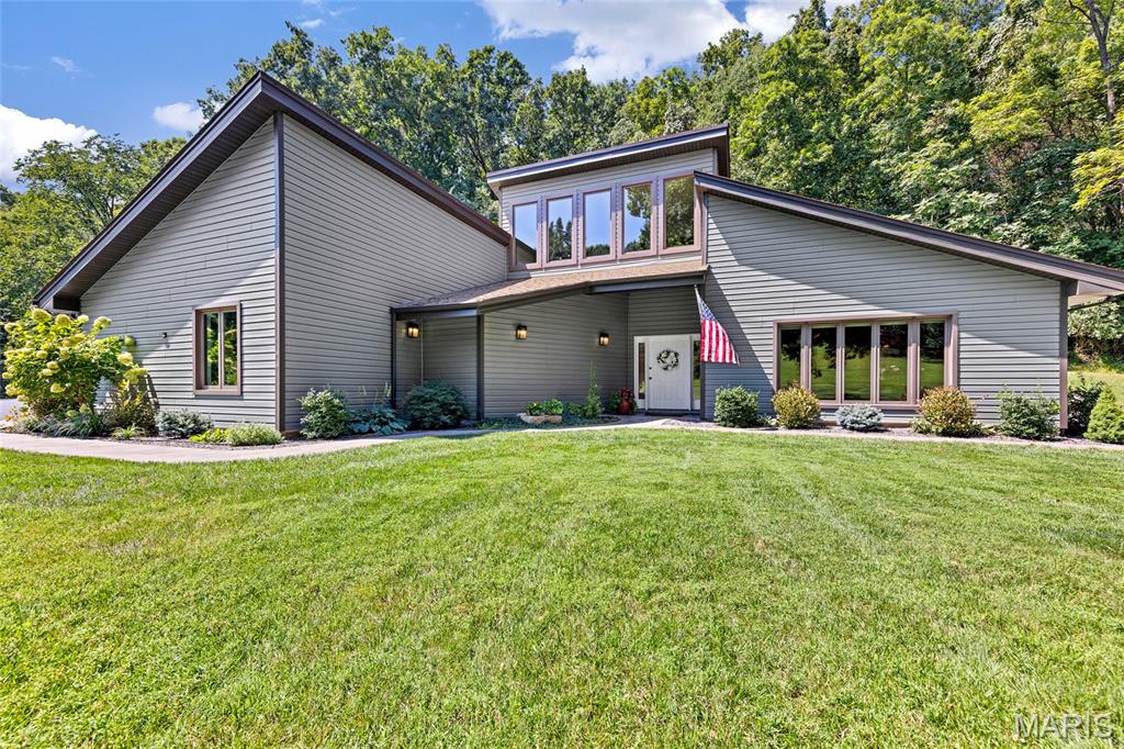 Private Retreat in Desirable Sugar Creek Farms! Tucked away on 2.9 acres, this spacious 3-bedroom, 2.5-bath contemporary home with approximately 2,500 sq. ft. offers the privacy and peaceful setting you've been looking for without sacrificing convenience. Surrounded by mature trees and set back from the road, you'll feel tucked away from it all, yet you're still just minutes from major highways, shopping, restaurants and everyday conveniences.

Step inside to a bright, open interior where vaulted ceilings, architectural details and abundant natural light create an impressive sense of space. The beautifully appointed kitchen features shaker-style cabinetry, quartz countertops, custom tile backsplash, center island with cooktop, stainless steel appliances and a spacious pantry. Just beyond, the dining area offers a wet bar and built-in cabinetry with glass doors, perfect for entertaining. The inviting living room is a true focal point with its dramatic vaulted beamed ceiling, expansive windows and wood-burning fireplace with updated tile surround. Convenient main-floor laundry completes the thoughtfully designed living space.

The spacious primary suite offers a relaxing retreat with a redesigned 8' x 8' closet by Closet Factory and a generous private bath with double sinks and separate shower.

The oversized 3-car garage is a standout, featuring decorative epoxy flooring and a dedicated workshop with heating and cooling plus its own half bath—an incredible setup for a hobbyist, car enthusiast or anyone looking for additional functional space.

Recent improvements include a new asphalt driveway, paver walkways and patio, updated landscaping, Andersen windows facing the street and Andersen sliding door, luxury vinyl flooring throughout, and a new water heater and pressure regulator.

With nearly 3 acres to call your own, there's plenty of room to relax, entertain and enjoy the outdoors in a setting that feels worlds away—while everything you need is just minutes from your door.