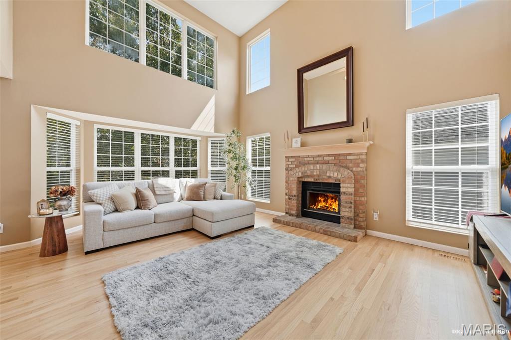Bright. Bold. Inviting!

Open, bright and beautifully connected to its treescaped surroundings, this Ballwin two-story makes an impression with a soaring great room, two levels of windows, blonde hardwood floors and a finished walkout lower level. Multiple outdoor living areas overlook a backyard bordered by tree-filled common ground, creating a peaceful setting just minutes from everyday conveniences.
From the welcoming front porch, step inside to an airy main level where the two-story great room takes center stage. A fireplace flanked by windows adds a warm and inviting focal point. A wall of windows and large bay window bring in abundant natural light, while the open breakfast area connects the great room and kitchen. Doors within the breakfast room bay lead to the deck—perfect for morning coffee, outdoor dining or simply enjoying the wooded view. Main-floor laundry and a half bath add everyday convenience. A two-car garage connects directly to the home through the kitchen.
Upstairs are three bedrooms plus a versatile bonus area offering options for a home office, study space or potential fourth bedroom. The primary suite includes a private bath with a spa inspired jetted whirlpool tub and separate shower, while two additional bedrooms share another full bath.
Downstairs, the finished walkout lower level offers luxury vinyl plank flooring, a wet bar and generous flexible living space for entertaining, recreation, fitness or hobbies, along with unfinished storage. Walk directly outside to the backyard and step-down flagstone terrace, an ideal setting for a firepit surrounded by the changing seasons.
A pathway from the back of the cul-de-sac offers a short stroll to the subdivision pool, and Oak Brook Elementary is also an easy walk away—completing a home that combines space, sunlight, flexibility and a wonderful Ballwin location.