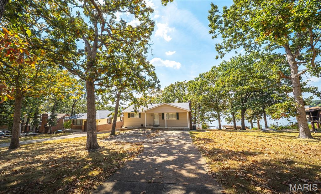 This lake home has been meticulously maintained and is perfect for enjoying the lake all year round! You will love the privacy of the treed lot, the gorgeous year round views and the easy walk to your own private dock! The dock and boat lift are newer and ready for you to enjoy lake life! When you enter the home, the main level has a family room and 4 spacious bedrooms and an updated bath. The lower level features kitchen, dining and living room with wood burning fireplace. Also on this level is another spacious bath, storage and laundry room. The kitchen has granite counters, cabinets with pull out shelves and a gorgeous view of the lake. Your entertaining area expands to the HUGE sun room. From there, its an easy walk to the water! Indian Lake 326 acres (+/-) of fun! Boating, fishing, swimming, skiing tubing and jet skis will fill your time! There's also a sandy beach, pickleball/tennis courts, horsehoes, and basketball. A full service marina makes lake life easy!