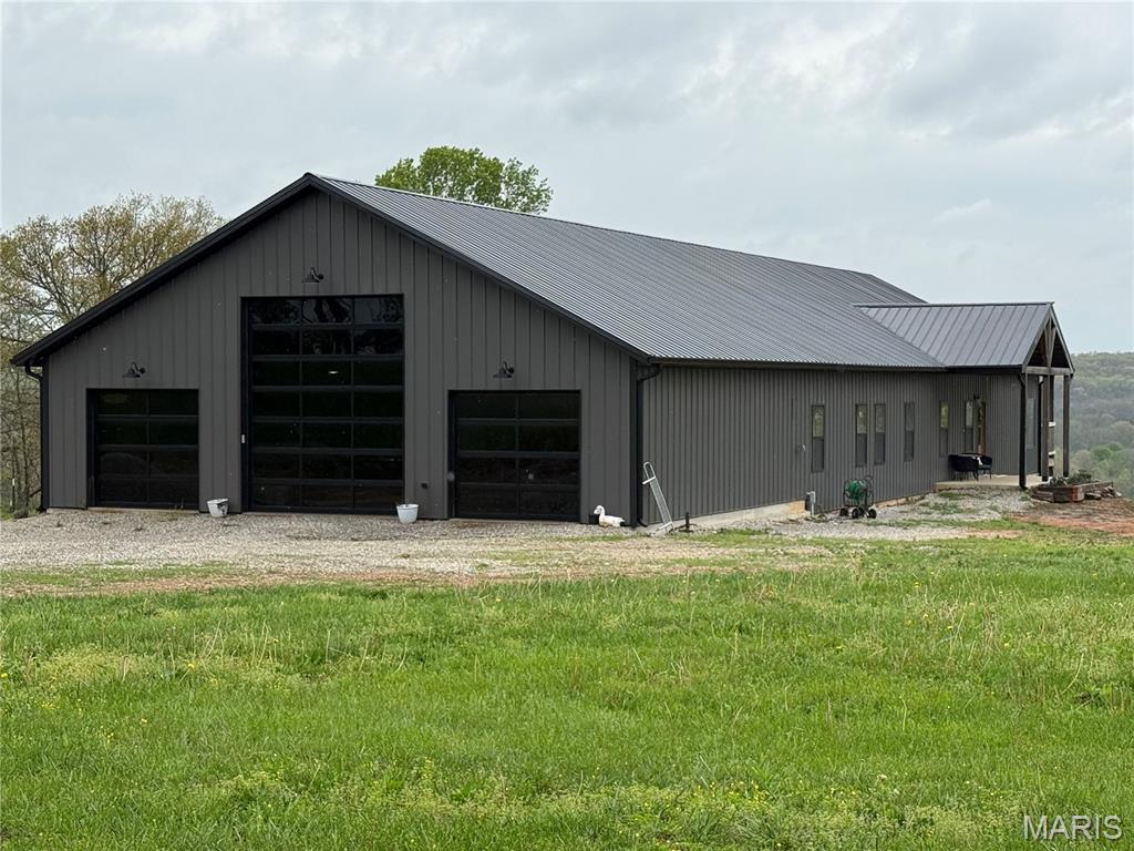 Set on 5 breathtaking acres with panoramic views that stretch for miles, this extraordinary barndominium blends luxury living with rugged charm in a truly one-of-a-kind setting. Designed with both comfort and functionality in mind, this four-bedroom, three-and-a-half-bath home showcases an expansive open floor plan, soaring spaces, and oversized bedrooms—each featuring its own walk-in closet for exceptional storage and convenience.
The heart of the home is a stunning chef’s kitchen, thoughtfully designed for both everyday living and entertaining, flowing seamlessly into the main living area. Just beyond, the covered back deck offers truly breathtaking, unobstructed views—an elevated vantage point where you can relax, entertain, and take in miles of rolling landscape in every direction. The covered patio below extends your outdoor living options even further.
The luxurious primary suite is a true retreat, complete with a spacious walk-in closet and a spa-inspired en suite bath featuring a massive walk-in shower and a deep soaking tub—designed to deliver comfort, elegance, and a private escape that rivals high-end resorts.
The 1,400+ square foot attached garage doubles as an impressive shop space, perfect for hobbies, storage, or equipment—offering versatility rarely found in homes of this caliber.
Additional features include a partial basement, durable concrete floors, painted interior walls for a clean, modern finish, and a wood-burning furnace that adds both efficiency and rustic appeal.
Bordering National Forest land, this property offers unmatched privacy, direct access to nature, and a lifestyle that’s equal parts luxury retreat and outdoor paradise. A rare opportunity to own a high-end rural escape with refined finishes and unforgettable views.