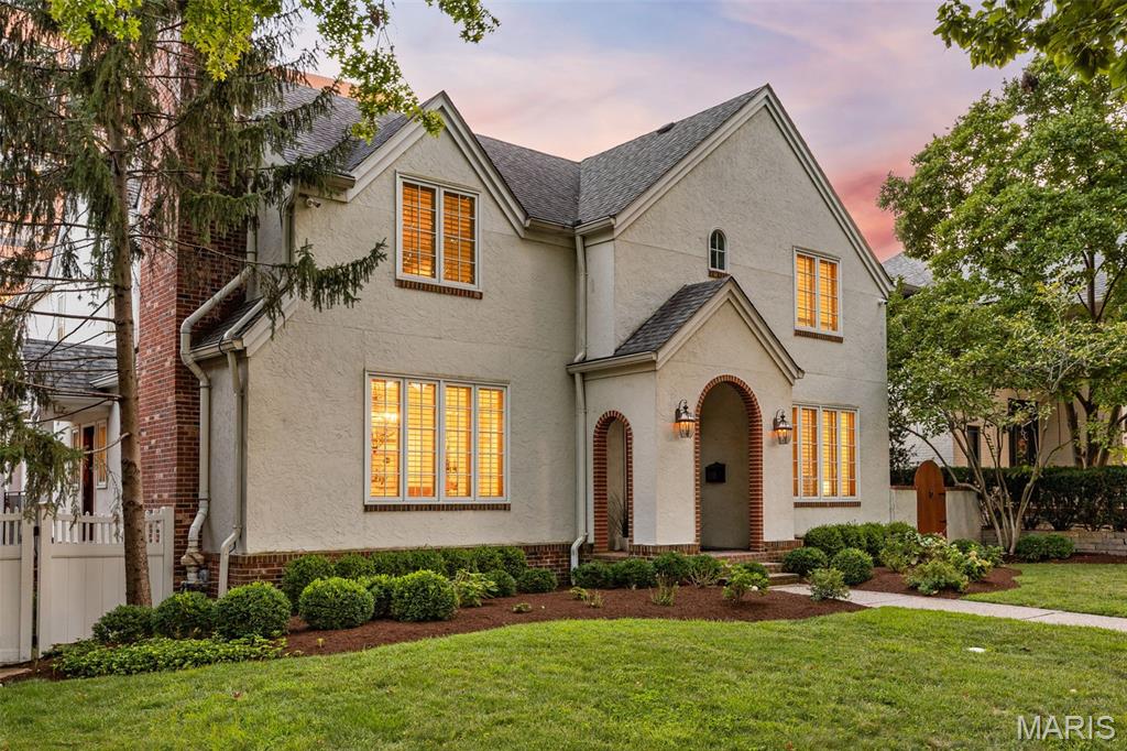 In the heart of Clayton, 8130 Westmoreland pairs storybook architectural charm with expansive interiors, exceptional versatility, and a rare Guest House plus 3-car garage. Just a block from the financial center of St. Louis and moments from parks, restaurants, shops, and cultural amenities, this distinctive residence offers gracious spaces for elegant entertaining, everyday living, quiet retreat, and extended guest stays. A marble foyer and graceful staircase introduce beautifully detailed interiors, including a light-filled front living room, richly paneled fireplace den, formal dining room, multiple gas fireplaces, wide moldings, plantation shutters, and generous gathering areas throughout. The chef’s kitchen features a 6-burner Dacor gas range, Sub-Zero refrigerator, extensive cabinetry, and a full butler’s pantry connecting to the dining room. An additional catering/prep area with half bath provides outstanding support for entertaining and also offers the option for main-level laundry. Upstairs, the impressive primary suite feels like a private retreat, with French doors, its own foyer, balcony, sitting area with coffee station, custom walk-in closet, and a spa-inspired bath with double-sided shower, jetted soaking tub, and separate water closets. Two additional bedrooms each offer en-suite full baths, while the walk-out lower level includes a fourth bedroom suite, theatre room, kitchenette/wet bar, large gym area, fireplace, and generous recreation space. A rare Clayton advantage, the detached Guest House plus 3-car garage adds extraordinary flexibility for guests, extended family, au pair quarters, private office space, or long-term use, while also providing exceptional parking and storage. With expansive interiors, skyline views, gracious entertaining spaces, and a premier Clayton location, 8130 Westmoreland is a distinctive residence offering both presence and possibility.