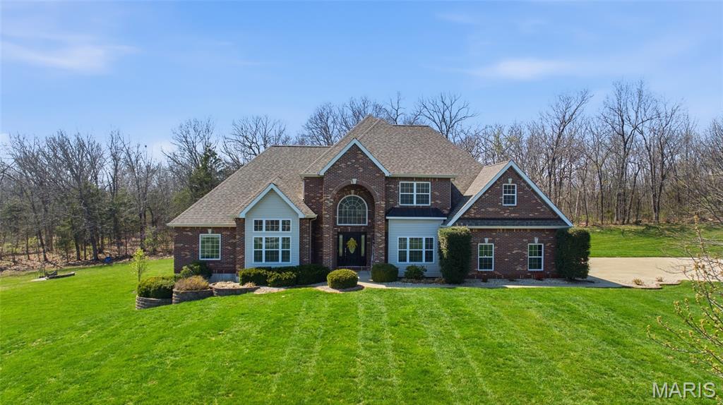 Beautifully maintained custom brick home with timeless architecture, a soaring entryway, and nearly 5,000 square feet of finished living space, all set on a picturesque 3 acre lot in Southern Lincoln County. This 4 bedroom, 3.5 bath residence offers a spacious, thoughtfully designed layout that blends comfort, function, and elevated everyday living.  The interior showcases an open concept design with hardwood and ceramic flooring throughout the main living areas, creating a seamless flow that supports both daily living and entertaining. Generously sized rooms provide a balance of comfort and flexibility, allowing the home to adapt to a variety of lifestyles.  The primary suite offers a true retreat, featuring a spacious bedroom, expansive walk in closets, and a spa like primary bath complete with a jetted tub, separate shower, and dual vanities.  The upper level includes two additional bedrooms, a full bathroom, and a large recreational area, providing additional living space for gathering, media, or relaxation. The finished walkout lower level further enhances the home’s versatility, complete with a full wet bar, expansive living area, exercise room, fourth bedroom, and full bath, creating an ideal setup for hosting, extended living, or overnight guests.  
An oversized three car garage with a dedicated workspace adds both functionality and convenience, while supporting storage, hobbies, or projects.  The outdoor setting offers a private backdrop with a covered back patio and fire pit area, providing additional space to unwind or entertain while enjoying the beauty of the outdoors. Recent updates include a new roof in 2022, new upper level HVAC unit in 2025, and new main level HVAC in 2023, offering added value and peace of mind.  This home brings together privacy, rural living, and luxury in a way that is increasingly difficult to find, offering the space, setting, and design for true estate style living. Located approximately 20 minutes from Wentzville and 10 minutes from Troy, this property offers the balance of privacy and convenience. You will not want to miss your opportunity to be the next homeowner.