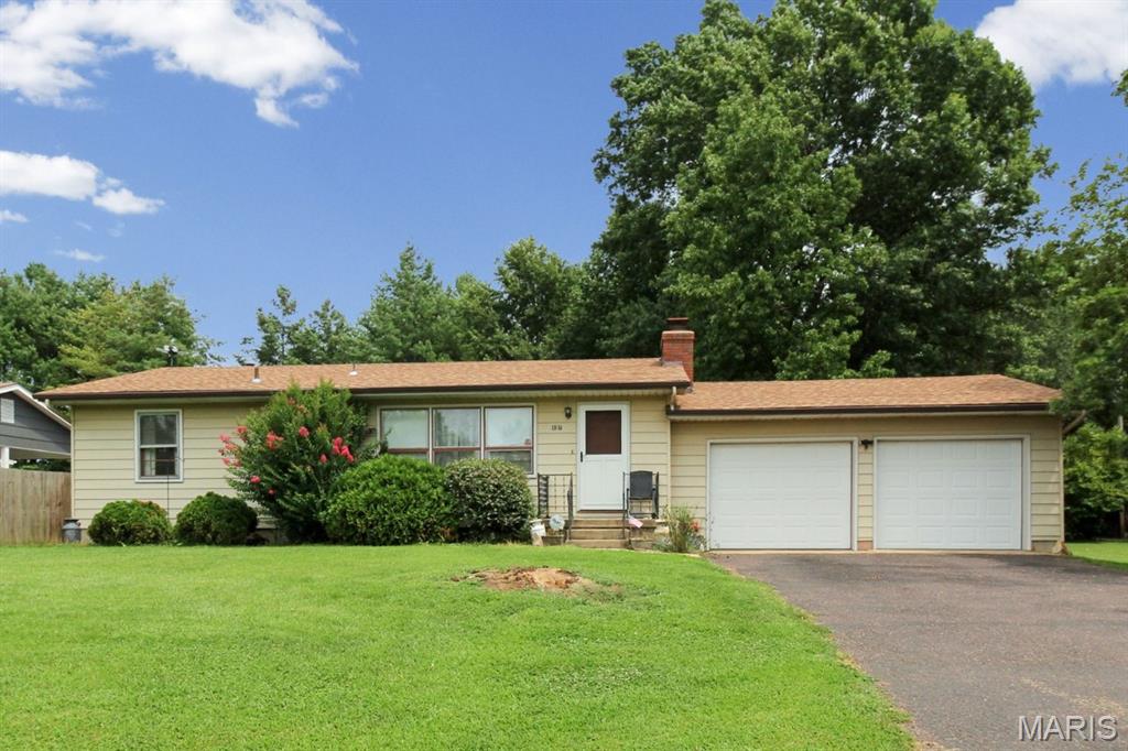 More space than meets the eye—and nearly an acre across two parcels! This 2-bedroom home is being sold with the adjoining land-only corner lot, providing a combined .8821 acres with plenty of open yard plus a wooded area to enjoy. Inside, hardwood floors extend throughout most of the main level. The spacious living room features a brick fireplace and abundant natural light, while the separate dining room leads to a generously sized eat-in kitchen with gas range, dishwasher and ceiling fan. The nice-sized primary bedroom offers a large closet and ceiling fan. A heated enclosed sunroom overlooking the backyard provides a wonderful spot to relax and enjoy the setting. The partly finished lower level offers additional recreation/living space and a second full bath, while the unfinished portion features custom-built wood shelving to help keep your storage needs organized. Additional highlights include a 2-car garage and roof approximately 5 years old. With just two owners since it was built, two parcels totaling .8821 acres, mature trees and flexible living space, this longtime home is ready for its next chapter.