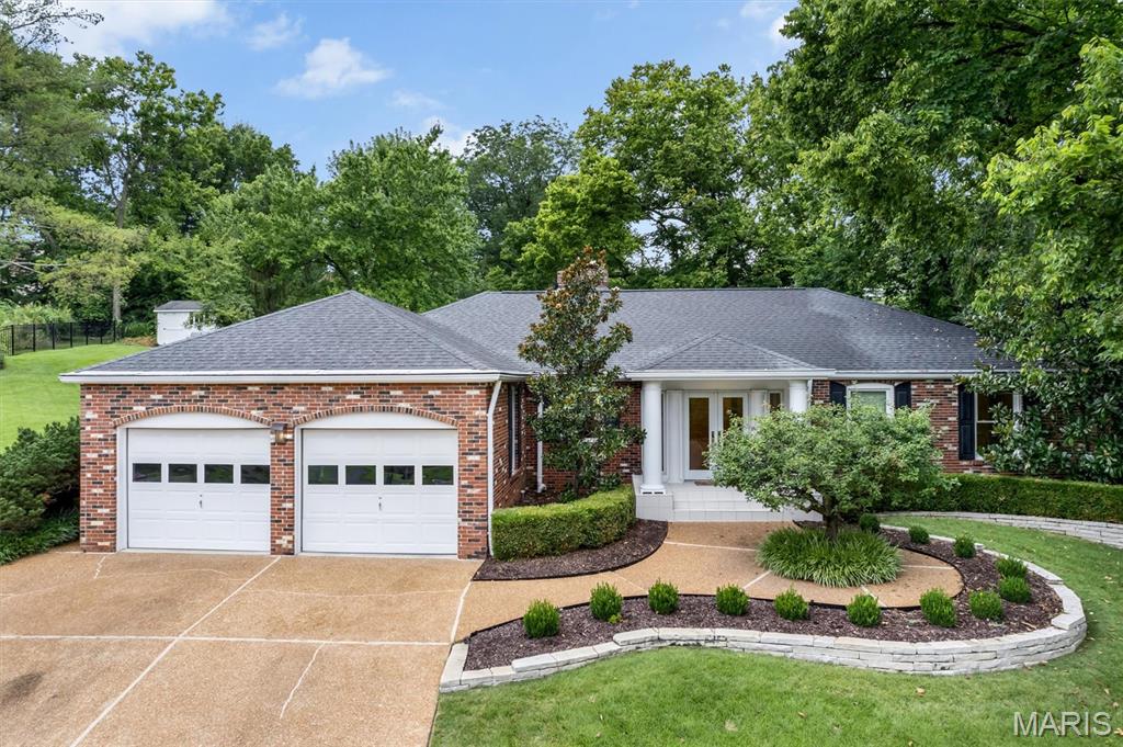 Architecturally distinctive. Decidedly original. Located in Greenbriar Woods, just a short walk from Greenbriar Hills Country Club, this nearly 3,200-square-foot, Deco-inspired contemporary ranch offers three bedrooms, 2.5 baths and a remarkable connection to its surroundings. Set amid exquisite landscaping and mature trees, this private retreat features sculptural curves, dramatic ceilings, custom built-ins and windows spanning nearly the entire rear elevation of the home. Designed with entertaining in mind, the expansive dining room opens directly to a secluded patio enhanced by a tranquil waterfall. The formal living room is equally memorable, featuring a fireplace, custom wet bar with beverage refrigerator, built-in display cabinetry and a dramatic recessed ceiling with integrated lighting. The vaulted great room serves as the home’s architectural centerpiece—anchored by a soaring stone fireplace and surrounded by three walls of windows framing the lush grounds and opens to a second private patio that also connects to the primary suite, creating a peaceful indoor-outdoor retreat. The truly custom kitchen offers streamlined cabinetry, generous workspace, a peninsula, pantry and two ovens, along with a light-filled breakfast room that also opens to the waterfall patio. The spacious primary suite features direct patio access, a separate tub and shower and a walk-in closet with custom storage systems. Two additional bedrooms provide comfortable accommodations or flex space. A mudroom with main-level laundry and half bath adds everyday convenience. An attached two-car garage, multiple patios and beautifully established gardens complete the property. Enjoy golf, tennis, swimming and social amenities available through membership at nearby Greenbriar Hills Country Club, along with the acclaimed Kirkwood School District and quick access to the shops, restaurants, farmers’ market and charm of Downtown Kirkwood. Refreshingly unlike anything else on the market, this special home may be preserved as a distinctive example of late-century design or thoughtfully reimagined for the next generation.