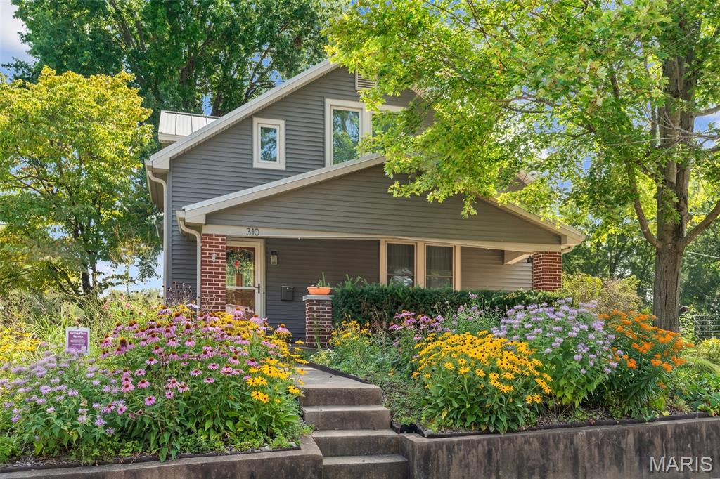 First things to know about this home how efficient it is. Big ticket items are all done.  Metal roof on house and garage.  Yes garage!!  Large tandem style garage fitting two vehicles easily.  Finding a garage this large near downtown is rare.  You have an electric car?  Non issue,  as there are TWO EV charging stations already installed. More energy saving  with SOLAR PANELS installed on the garage.   More...This home has a geotherm system, Updated Electric Panel, two hot water heaters and a water softener.  ALL new windows installed less than 7 years ago.  
Now to the charm!  There are three bedrooms upstairs with a full bath and ample closet space.  The main level has a large living area, dining area, full kitchen, Bedroom and full bathroom.   It has plenty of space for everyone.   Now the outside- Retaining wall built in 2017, the front and side yards has been planted with all perennial native Missouri wildflowers, and are in second year so next year should be fantastic!  All that pollination ! Covered front porch, driveway that leads to that  awesome garage and a side walk leading to the back patio.  The back yard is something to see.  Over 1/3 acre lot which is quite large for a home in the downtown Washington area.  The  patio that is partially covered and leads out to a large level back yard which is private and fully fenced.  Close to hospital, doctors, eateries, schools, churches, parks, playgrounds and shopping.   Always something to do with the River Trail, Sunset on the River Front, Wine Fest, Art Fair, farmers market and so much more.  Fall is near and there is fun stuff to do just a couple of blocks away.  Come check out this really cool home and see why everyone loves Washington !
