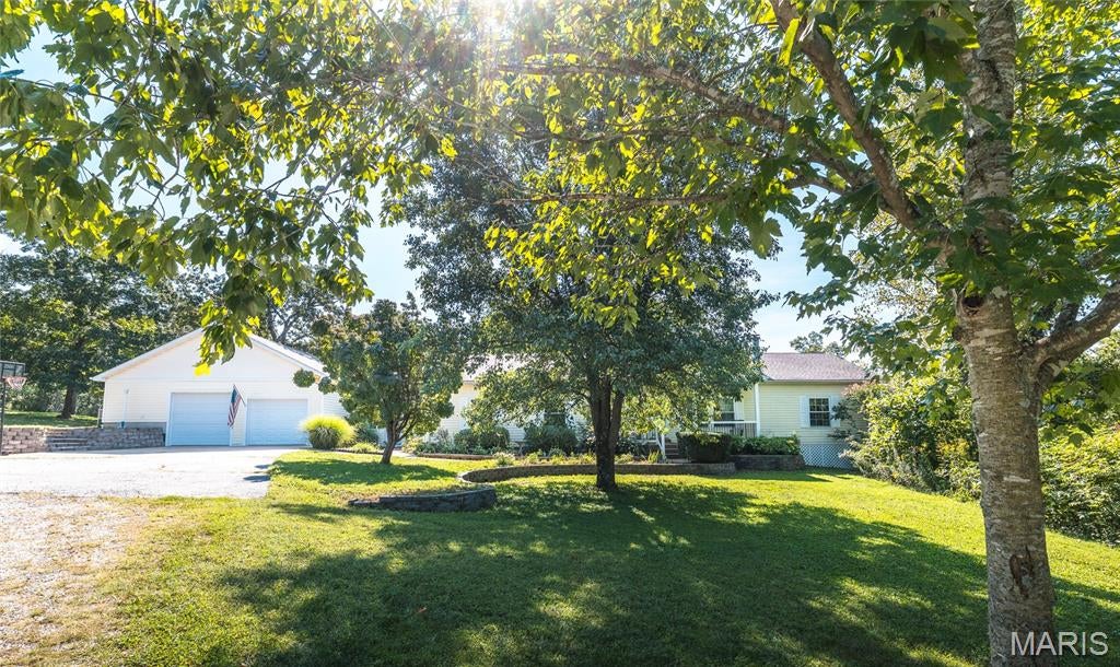 Step into this beautiful 8.14 acre country estate, offering an abundance of space, privacy, and possibilities! With 3,019 sq. ft. on the main level plus approximately 1,500 additional living sq. ft. in the lower level, this spacious home features 3 bedrooms, 1 non-conforming bedroom, and 3 full bathrooms. Right in the heart of the home is the generously sized kitchen featuring an island, breakfast bar, breakfast nook, and formal dining area. The open floor plan flows from the formal living room with a wood burning fireplace into the office or den, while a sunny breezeway with an nice atrium leads to the impressive family room, providing plenty of space to gather, entertain, or simply relax. The spacious primary suite is tucked away for added privacy and features an updated step in shower and walk-in closet. Two generously sized bedrooms are located in the guest quarters. Additional highlights include 9’ ceilings, zoned HVAC, and an oversized attached 2 car garage with plenty of room for vehicles and storage. Outdoor living is just as impressive! Enjoy the maintenance free Trex deck and expansive patio overlooking the 30 foot round pool, perfect for cooling off on warm summer days. The landscaping features numerous beds filled with native Missouri perennials, allowing you to enjoy as much or as little gardening as you’d like. With additional workspace, the 30x40 outbuilding is equipped with electric, water, a bathroom, kitchenette ideal for processing/butchering, and a walk-in cooler, making it an incredible workshop, hobby space, or small farm setup. A large parking area and circle drive provide plenty of room for guests, trailers, and equipment. With no HOA, you’ll have the freedom to truly enjoy this property. Naturalists, gardeners, hobby farmers, and anyone looking for room to spread out will appreciate everything this property has to offer. The lower level also provides exciting possibilities for additional living space or potential short-term rental use. Recent updates include a new dishwasher, disposal, A/C unit, and pool filter. Whether you’re searching for a peaceful country retreat, a spacious family home, or a property with income potential, this unique estate offers endless possibilities!