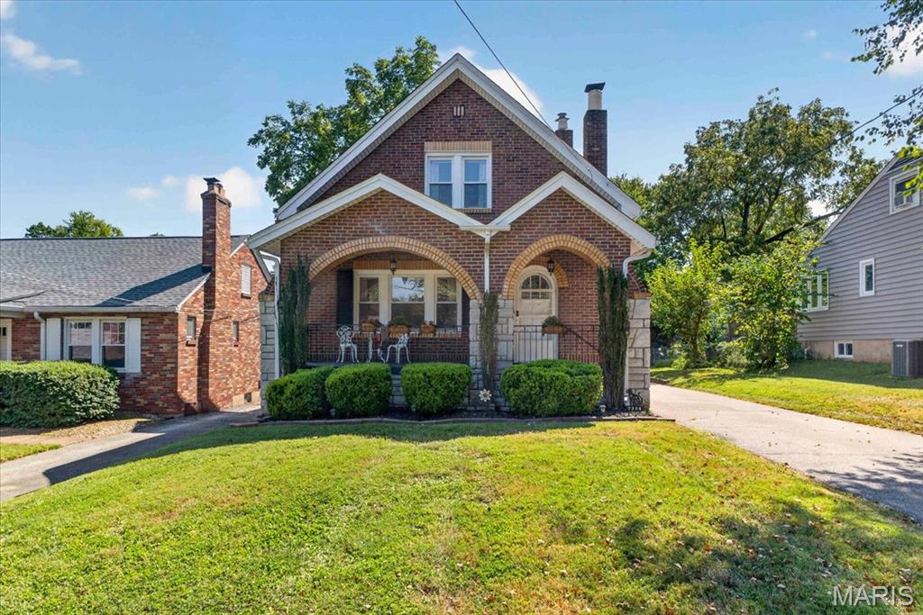 You’ll love this charming brick bungalow situated in the desirable Webster Groves School District. From the moment you arrive, the eye-catching exterior welcomes you with iconic brick arches, stone accents, and a spacious covered front porch featuring warm wood arch ceilings. Inside, the home seamlessly blends classic character with major modern updates. Gleaming hardwood floors, thick crown molding, cedar-lined closets, and arched doorways set the stage, while the cozy living room centers around a decorative fireplace flanked by custom dark-wood shelving and vintage stained-glass accent windows. Flowing naturally from the living area is a formal dining room, convenient main-floor laundry, and a full bathroom with classic original tile. The well-equipped kitchen features rich wood cabinetry, granite countertops, a tile backsplash, two sinks, and stainless steel appliances with a gas range. Just off the kitchen is a versatile flex room—perfect for a breakfast nook or sitting area. Upstairs, three bright bedrooms feature warm hardwood floors and ceiling fans, served by an updated full hall bathroom. Off the rear, a light-filled enclosed sun porch surrounded by wraparound windows creates the ultimate retreat for morning coffee or relaxing with plants. Downstairs, the partially finished basement provides flexible space for a rec room, office, or gym, alongside abundant storage. Outside, the oversized detached garage includes a dedicated workshop space for hobbies and projects. You'll enjoy complete peace of mind with major mechanical upgrades: a brand-NEW ROOF (May 2026) with a transferable warranty, new sunroom siding, a new electrical panel (July 2026), and serviced dual HVAC systems for zoned comfort. Valuable extras stay with the home, including the washer and dryer, living room piano, bedroom wardrobe, built-in basement shelving, and a full set of lawn tools. Delivering rare personality, key updates, and a top-tier location, this move-in-ready gem is ready for its next chapter!