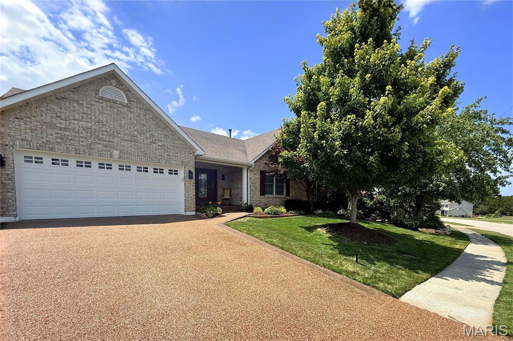 Stunning upgraded OPEN PLAN VAULTED ranch with FINISHED WALKOUT lower level and beautiful backyard - right across the street from 157-acre Wentzville Golf Club, short walk to COMMUNITY POOL and scenic trail. Elegant curb appeal with FULL-BRICK front, coordinating mailbox, covered front porch, architectural shingle roof, coach lights and GORGEOUS LANDSCAPING with irrigation. Soaring ceilings with 10-ft back wall, and wonderful natural light throughout. Welcoming great room with decorative fireplace, brick hearth and breezy ceiling fan, open to kitchen. Generous 42" wood cabinets with crown, massive CENTER ISLAND BAR seats 8, GRANITE COUNTERS, custom tile backsplash, STAINLESS APPLIANCES, smooth-top range with convection, double oven and water-resistant luxury vinyl plank flooring. Dining area bay steps out to deck overlooking peaceful yard - great for gatherings. Relaxing primary suite with bay window, dual vanity, soaking tub, separate shower and WALK-IN CLOSET. Huge 2nd bedroom with 4-ft extension. Secondary bedrooms share hall bath with granite vanity and glass-enclosed tub/shower combo. Downstairs flexible spaces include rec room with walkout to patio, GUEST QUARTERS, media/theater, plus storage. Private vinyl-FENCED BACKYARD with space to play, garden and entertain. Nonslip aggregate driveway/walk/porch. Upgraded HVAC with humidity control. WELL-MAINTAINED one-owner home. Close to Highways 70/64/61 in AWARD-WINNING SCHOOL DISTRICT, with most daily errands within 2 miles.
