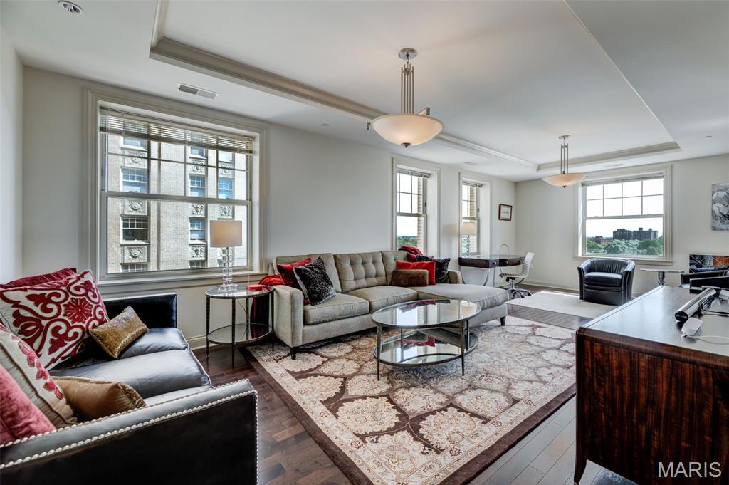 Fabulous corner unit at the Private Residences at the Chase featuring stunning eastern views and a spacious, open floor plan. This luxury condo offers 1,240 square feet of refined living space in the heart of the Central West End and includes two secure garage parking spaces. The elegant entry with coffered ceilings flows into an updated gourmet kitchen equipped with professional-grade Thermador appliances, custom cabinetry with crown molding and pull-outs, a gas range, a stainless hood, and sleek granite countertops. The formal dining room and living areas feature additional coffered ceilings, hardwood flooring, and designer chandeliers overlooking the beautiful terrace and downtown skyline. The primary suite serves as a private retreat with a custom walk-in closet and a spa-like bath featuring raised double-sink vanities, stone flooring, a glass shower, and a jetted tub. Complete with a Bosch washer/dryer and Danze plumbing fixtures, this residence offers an unmatched lifestyle with access to a green terrace with two Wolf gas grills, a concierge, valet parking, and three on-site restaurants just steps from the movie theater and all the CWE has to offer.