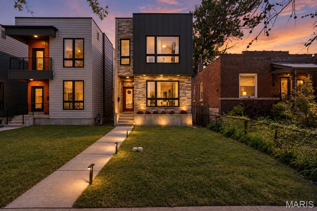 This home has a point of view! Wrapped in natural stone and dramatic charcoal siding with oversized black-framed windows, this home's architectural silhouette feels almost like a modern mountain retreat rather than a city residence. It makes an impression before you even walk through the door. Inside, the mood shifts effortlessly. Warm wood floors temper crisp contemporary lines, while a striking glass-enclosed staircase becomes an architectural feature of its own. Open staircases to both the upper and lower levels extend sightlines from floor to floor, creating a sense of volume, connection, and light — giving the home a decidedly unexpected edge. The main level brings the living room, kitchen, and dining room together in one beautifully connected space, filled with natural light. At the center, an oversized rich blue island anchors the kitchen, surrounded by tailored cabinetry and stainless-steel appliances. There's plenty of room to gather at the island, while the adjacent dining area is bright, spacious, and ready for hosting. There’s also a perfect city-sized backyard and patio with a privacy fence. Upstairs, you’ll find the bright and spacious primary suite featuring double closets, a floor-to-ceiling tiled shower, clerestory window, pocket door, and double vanity. Two additional bedrooms, a full hall bath with tub, and second-floor laundry complete the level. Don’t forget to make your way down to the lower level—which hardly feels like a basement at all. With 9-foot ceilings, more natural light, an egress window, and plumbing already in place for an additional bath, it's ready to become whatever you envision. Thoughtfully curated finishes throughout this special home create a sophisticated, warm aesthetic in one of the area's most dynamic neighborhoods, known for its thriving restaurant scene and convenient lifestyle amenities within walking distance. You’re a quick stroll or bike ride from St. Louis’ greatest parks and the Missouri Botanical Garden, with BJC, WashU, and SLU medical campuses just minutes away. Brand new sidewalks and bike paths await your adventures! A two-car garage adds another layer of convenience, although with this location, you may find yourself walking or biking more often than driving. Hurry and come see this unique beauty!
