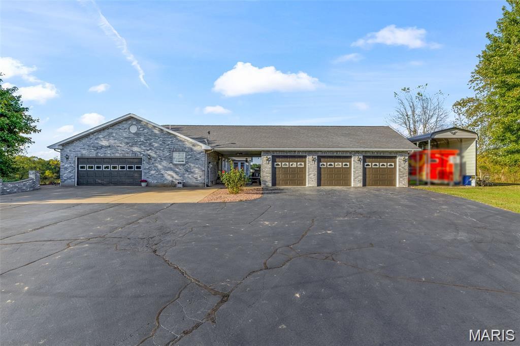 This stunning 4-bedroom, 3.5-bath home is exactly what you’ve been searching for. As you approach, you’ll fall in love with the beautiful 900-foot paved driveway that sets the tone for the entire property. Step inside to an open-concept design featuring vaulted ceilings, updated flooring, remodeled bathrooms, a brand-new butler’s pantry, and a spacious central living area. The large primary suite offers a beautifully updated en-suite, while the finished basement provides even more living space. A 5-car garage ensures abundant room for vehicles and storage. Outdoors, enjoy a 1-acre lake with a pavilion, a covered patio, and an impressive 55x32 barn with concrete floors, along with additional outbuildings. High-speed internet is also available. This one-of-a-kind property blends beauty, functionality and privacy all in one location. Additional acreage is also available if the buyer is interested.