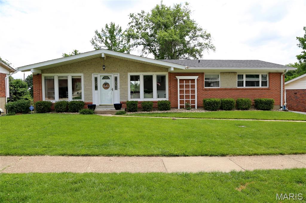 BEAUTIFULLY UPDATED! OPEN FLOOR PLAN! FINISHED WALK-OUT BASEMENT W/2ND KITCHEN! Enter to entirely open main floor area with wood flooring--kitchen, dining, and very large family room. Shiplap accent wall with electric fireplace insert is flanked by newer built in cabinets/shelving. Kitchen boasts white cabinets, stainless steel appliances, oversize double sink. & charming barnwood added to one wall. Gas range with double oven. Oversize replacement windows throughout let in loads of natural light. Down the hall, full bath has been updated with granite counter, rectangular tile flooring, & newer tile surround in tile/tub area. Wood flooring & ceiling fans in all 3 bedrooms. Primary bedroom boasts an updated private full bath--newer vanity, mirror, toilet, rectangular tile flooring, & tile surround in shower w/built in niche. Next, check out the open stairway down to another 793 sq. ft. of living space in the finished walk-out lower level--complete with a small kitchen, living area, playroom/sleeping area, laundry room, & 3rd full bath. Low-maintenance painted concrete floors throughout. Exterior door off the living area leads directly to the AMAZING, well cared for, spacious fenced yard! Patio area just outside the lower level is covered by a beautiful pergola. Note the circular built-in firepit area & large playground structure. Rear entry garage with oversize parking pad allows lots of room for turn-arounds, extra parking, & additional play area. Architectural shingled roof is 1 year old and AC is only 2 years old! Great location, just off Mattis Road, minutes from I-270/Tesson Ferry. MUST SEE!