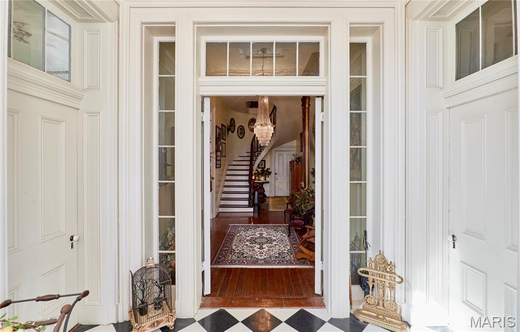 If these walls could talk, they would tell elaborate stories that encompass almost 170 years from tall tales to historical facts.  This Grand Historic Italianate style solid brick beauty was built in 1858 by James H. Johnson, a riverboat captain.  Other owners include John B Henderson (author of the 13th amendment) and Paul C Stark Sr of Stark Bros Nurseries.  This home has been lovingly preserved with the majority of original details plus modern amenities added.  Enter into the foyer through solid wood double doors and be transported back in time. Slowly make your way into the grand center hall with a view of the floating stair, glistening chandelier (relocated from the Visitation Academy of St. Louis by Theodosia Stark in 1945) and be astounded by the massive floor to ceiling mirror (relocated from the Peak Mansion in St. Louis by Captain Johnson) The majestic ballroom once used to entertain historical dignitaries boast ornate details, 2 fireplaces, walkout windows to the deck, and original interior shutters. The entire home is graced with 14-foot ceilings, and the 3rd story offers a cupola (find the hidden signatures of past owners) with a view of the mighty Mississippi River.  Enormous foldable pocket doors grace most rooms; 9 fireplaces with gorgeous mantels, and original plaster medallions ornately enhance the chandeliers throughout. Original summer kitchen was converted to a main floor suite.  Main floor kitchen was recently updated with all modern necessities. The back stairs lead to a second kitchen that once housed the indoor servants.  4 massive bedrooms with adjoining pocket doors located on the second floor each having its own fireplace.  Grand floor to ceiling library in the second-floor hall. The 2-story covered decks on the back of the home can be accessed through many doors and provide ample entertaining space.  Oversized 2-car brick detached garage with workshop area. Seasonally landscaped lot is enhanced with wrought iron fencing and original hitching post.  This stately residence has been featured on many historical tours and can easily be utilized as a B & B, wedding venue, multi-generational living, or your personal historical residence.