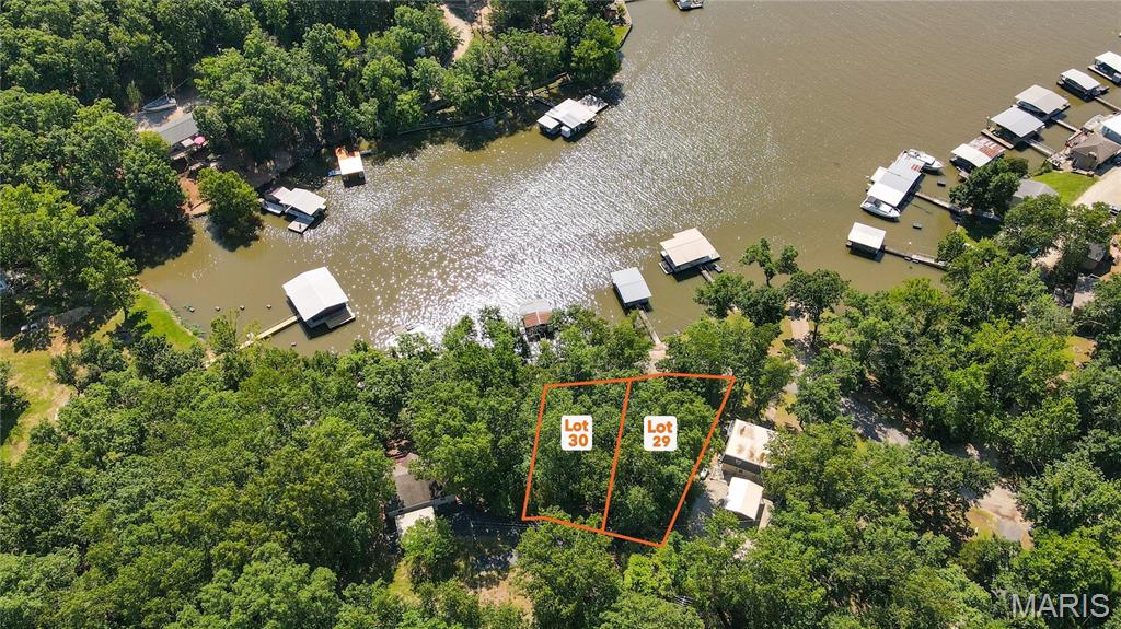 AUCTION LISTING - List price is not indicative of Seller’s final reserve amount.  This property is part of an online bidding event.  This sale will be executed with a no-contingency contract provided by brokerage representing the Seller. See MLS Supplement Document for complete details. Here is the perfect opportunity to build your dream home or lake getaway on the peaceful side of the Lake of the Ozarks. These attractive building lots offer the ideal combination of privacy, convenience, and excellent lake access. With blacktop roads leading all the way to the property, you'll enjoy easy year-round access without the hassle of gravel roads. Located directly across the road is the community lakefront, where you'll have the opportunity to install your own dock in a well-protected cove featuring good water depth throughout the summer pool season. Whether you enjoy boating, fishing, swimming, or simply relaxing by the water, this location provides everything you need to experience the lake lifestyle. The lots also offer beautiful lake views and are just steps away from the private community boat ramp, making it quick and convenient to launch your boat and spend the day on the water. Tucked away in a quiet cove, you'll enjoy a peaceful setting while still having easy access to all the attractions, restaurants, and amenities the Lake of the Ozarks has to offer. With two adjoining lots available for purchase, you have the flexibility to buy one lot that best fits your needs or purchase both for additional privacy, more building space, or room for extra parking, a larger home, or additional outdoor living areas. Whether you're planning a full-time residence, a vacation retreat, or an investment property(s), these lots offer outstanding potential. Don't miss this opportunity to own your own piece of the Lake of the Ozarks and start building the lake home you've always envisioned. Directions: Hwy 135 out of Laurie to left on 135-3(Cup Tree) follow all the way down to left on Avalon right before Johnson brothers. Follow Avalon around to property on left.