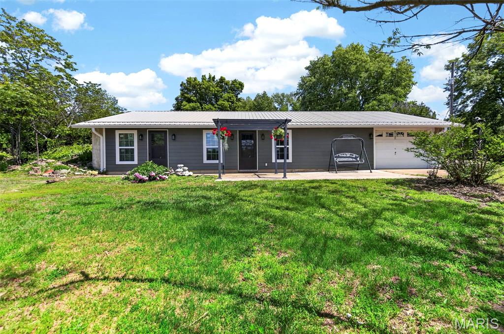 Set along Highway 19 in Crawford County, this 21+ acre property offers a rare blend of privacy, functionality, and natural beauty. A picturesque pond and multiple outbuildings provide endless opportunities for recreation, hobbies, or workspace. Inside, the home features a spacious, light-filled living room with an open floor plan that flows seamlessly into the kitchen and dining area, highlighted by hardwood floors throughout the main living space. The kitchen is equipped with an L-shaped center island/breakfast bar and generous counter space, ideal for both everyday living and entertaining.

The main floor primary bedroom includes a private entrance leading to the front porch. A full bath on the main level features a soaking tub and separate shower. Just off the kitchen, a versatile utility room adds convenience and flexibility for storage or a home office.

Recent updates include a new roof, siding, and windows, offering peace of mind for years to come. The lower level expands the possibilities with two large workshop areas and additional storage space. Tucked away yet easily accessible, this property is located just minutes from Mark Twain National Forest and the Meramec, Huzzah, and Courtois Rivers—perfect for outdoor enthusiasts seeking a private retreat.