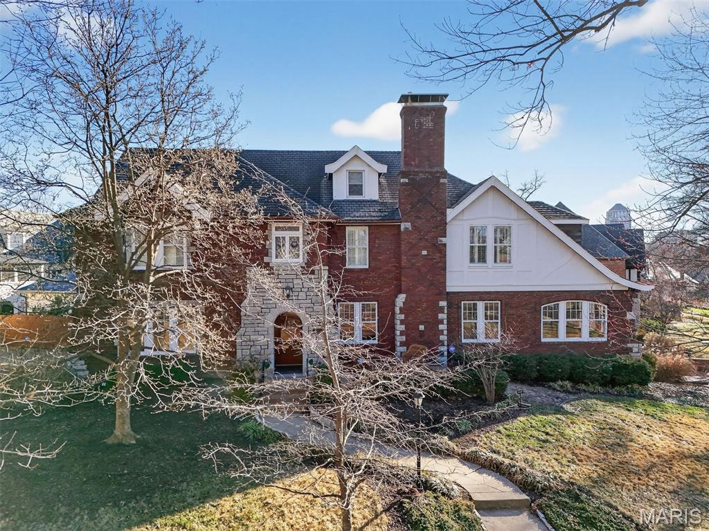 An iconic presence in University Hills, 7298 Greenway is one of the most admired and highly sought-after homes in the neighborhood. Long recognized for its architectural distinction, this residence blends historic craftsmanship with thoughtful modern updates. Intricate moldings, exceptional millwork, cane glass windows, and artisan ironwork define the home’s character, while graciously sized rooms are filled with natural light. Significant system upgrades — including HVAC, electrical, plumbing, sewer, windows, and roof — provide lasting peace of mind. A seamless addition introduces a dramatic family room with soaring 13-foot beamed ceilings and French doors opening to multiple patios. An oversized two-car garage offers rare convenience. The finished third floor provides flexible living with recreation space, bedroom, and full bath, while the expansive lower level is remarkably clean and dry. Located on one of the most prestigious streets in University Hills and just moments from downtown Clayton, the house on the curve is a rare opportunity in a truly coveted setting.