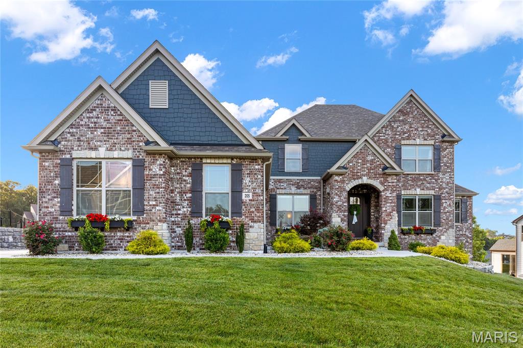 This spectacular brick-and-stone, 1.5-story Lombardo-built residence showcases exceptional craftsmanship, distinctive architectural details, and premium builder upgrades throughout. Soaring ceilings, elegant arched entryways, detailed millwork, and wide-plank flooring create a refined yet welcoming atmosphere from the moment you enter. A spacious covered front porch and impressive 8-foot entry door open to a gracious foyer, leading to a private study with a built-in work center, formal dining room, and stunning great room. The great room is anchored by a dramatic floor-to-ceiling marble fireplace flanked by custom built-in bookcases, while an expansive wall of windows captures breathtaking lake views and fills the home with natural light. Designed for both entertaining and everyday living, the chef’s kitchen features 42-inch custom cabinetry, granite countertops, premium stainless-steel appliances, a 48-inch professional range with a custom-crafted hood, and a generous 7-foot center island. The kitchen flows seamlessly into a bright breakfast room and sunroom, which opens to a covered deck overlooking the water. The luxurious main-level primary suite offers a private retreat, highlighted by a bay window with serene lake views and a spa-inspired bath featuring a freestanding soaking tub. An elegant oak staircase leads to the upper level, where three additional bedrooms include one with a private en-suite bath and two connected by a Jack-and-Jill bath. A spacious loft provides flexible living space ideal for a media room, playroom, or secondary lounge. The finished walkout lower level, enhanced by a 9-foot foundation pour, is designed for entertaining and extended living. This impressive space includes a recreation room, family room, full secondary kitchen, fifth bedroom, second laundry area, and full bath. Outside, resort-style amenities create an exceptional setting for relaxation and entertaining. Sliding glass doors lead to a spectacular outdoor living area featuring a pool with waterfall, outdoor kitchen, composite deck, expansive patio, and beautifully landscaped gardens overlooking the lake. Completing the property is an oversized 4-car garage, providing abundant space for vehicles, storage, and hobbies. Combining luxury, comfort, and stunning waterfront views and expansive entertaining space, this exceptional Westleigh Manor residence offers an unparalleled lifestyle both indoors and out.