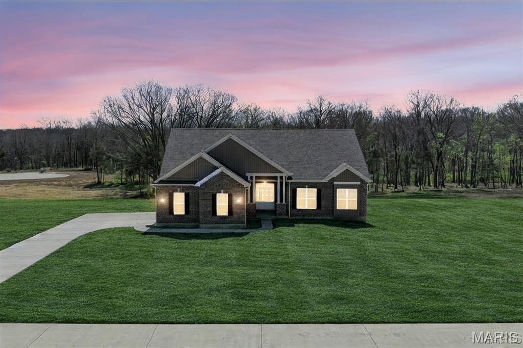Now Under Roof – Move-In Ready - SOD COMING SOON! Why settle for less when you can have it all? The Sycamore Model at The Estates at Schaper Farms offers the ideal blend of space, quality, and setting on a 3.05-acre walk-out lot in the sought-after Wentzville School District. This thoughtfully designed 3 bedroom, 2 bath ranch features 2,097 sq ft of open-concept living with upscale finishes throughout.
The exterior showcases a striking brick and board-and-batten facade with a side-entry oversized 3-car garage (30’ x 24’). Inside, enjoy 10-foot ceilings, 8-foot doors, and transom windows along the back that fill the home with natural light. The kitchen is designed for both function and style, offering 42” staggered cabinets, quartz countertops, a large island, walk-in pantry, soft-close doors, dovetail drawers, and stainless steel appliances including a double oven, ceramic cooktop, cabinet hood, and microwave drawer. LVP flooring runs throughout the main living areas with ceramic tile in the baths.
The private primary suite features dual vanities, a soaking tub, and a walk-in shower. The walk-out lower level includes a slider to the patio, providing easy backyard access and flexibility for future finish or outdoor living. Exceptional quality, generous acreage, and a serene setting—this home truly delivers. Dare to compare.
Join us Fridays 11-5:30 or Saturdays and Sundays 11:00 am-2:00 pm at the OPEN HOUSE and experience this property in person!