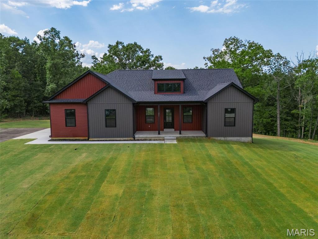 Welcome to this beautifully crafted 3-bedroom, 2-bath home offering 1,858 square feet of thoughtfully designed living space. From the moment you arrive, you’ll appreciate the home’s private setting on two spacious lots, backing to wooded acreage with no rear neighbors—providing both peace and seclusion on a newly paved street.  Inside, the home features a desirable open layout with vaulted ceilings, a large working dormer allowing ample natural light in. a large kitchen that serves as the heart of the home. It showcases custom-built cabinetry with quartz tops, large 9’ long island with a stunning custom wood top, large walk in pantry with wood tops and matching wood shelving, and a full stainless steel appliance package. Large laundry room with additional cabinetry add both style and functionality.  The primary suite is a true retreat, offering a spacious bedroom, a luxurious en-suite bath complete with a freestanding soaking tub, separate shower, and large double vanity, along with an expansive walk-in closet that conveniently connects to the laundry room. The second and third bedrooms are both nicely sized, and ceiling fans are installed throughout for added comfort.  Outdoor living is just as impressive, featuring a large deck with low-maintenance composite decking and sleek black aluminum railings—perfect for relaxing or entertaining. The home also includes an oversized two-car garage providing excellent storage or workspace potential.  Additional highlights include a full walkout unfinished basement with plumbing already roughed in for a future bathroom, a concrete sidewalk and garage apron, asphalt driveway, attractive vinyl siding, black exterior windows, and a charming wood porch ceiling.  This home offers the perfect blend of modern finishes, thoughtful design, and a quiet, private setting—ready for you to move in and make it your own.