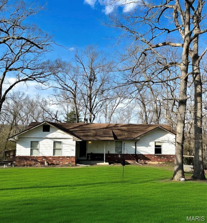 Solidly built ranch home offering incredible potential on 2.77 acres of scenic, wooded surroundings. This 3-bedroom, 2 full bath home features an open floor plan with a beautiful fireplace as the focal point of the living room.  The spacious primary suite includes a private en suite bath with double sinks and a newer vanity.  Enjoy additional flexibility with a front bedroom ideal for guests or a home office.  Added convenience with laundry on the main level.  The walkout basement is dry and provides excellent opportunity for future finishing or added living space.  Major updates include a newer water heater, updated electrical panel, and a roof approximately 10 years old. With just a few cosmetic touches, this property can truly shine and become a long-lasting, beautiful home.