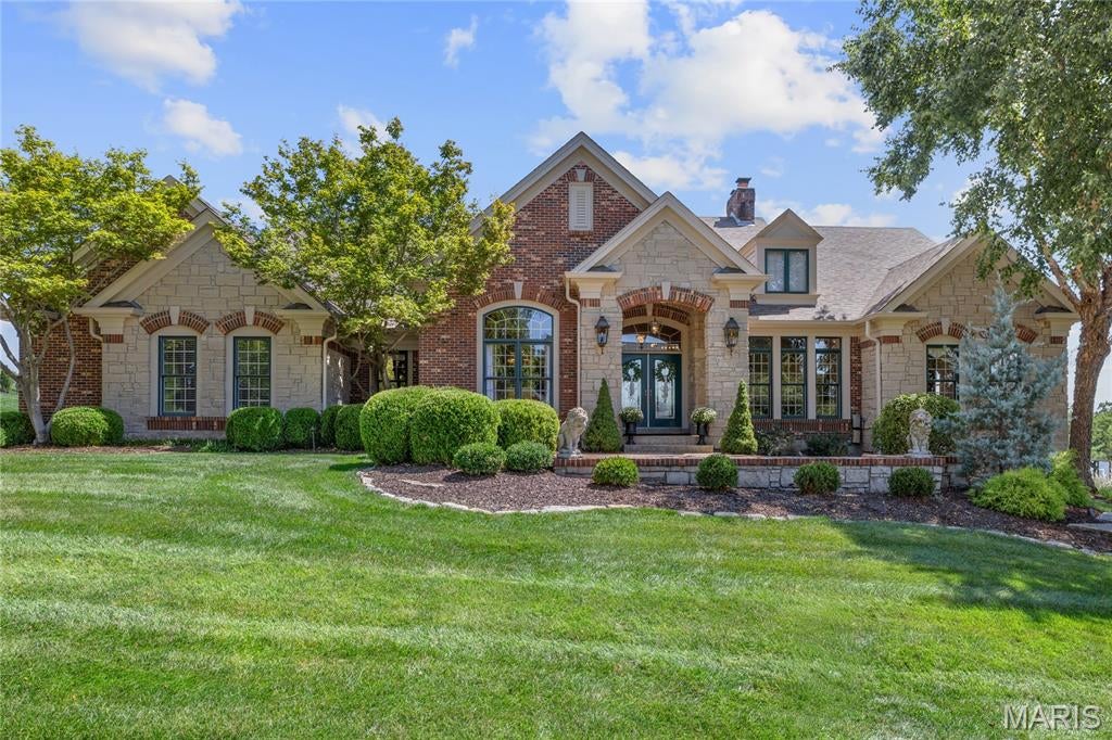 Experience award-winning luxury in this spectacular Homearama Showcase Award-winning ranch by Hardesty Homes, where exceptional craftsmanship and timeless design are showcased throughout. A welcoming front terrace leads to extraordinary double entry doors with leaded glass, opening into a grand foyer with soaring 12-foot ceilings, custom millwork, and rich white oak flooring throughout the main living spaces. The elegant study, framed by architectural columns, and the formal dining room with its striking octagonal ceiling create an impressive first impression. The breathtaking great room features a dramatic dimensional ceiling, a floor-to-ceiling cast stone fireplace flanked by custom built-ins, and an expansive wall of windows overlooking the beautifully landscaped, park-like grounds. Designed for both everyday living and entertaining, the exceptionally large kitchen offers 42-inch custom cabinetry, premium Monogram appliances, and an impressive 7-foot center island. The adjoining breakfast room, complete with a convenient planning center, flows effortlessly into the inviting hearth room, highlighted by a full-height brick and stone fireplace. The luxurious primary suite serves as a private retreat with a coffered ceiling and a spa-inspired marble bath featuring a soaking tub. A second ensuite bedroom completes the thoughtfully designed main level. A stunning atrium staircase leads to the expansive lower level, built with a 10-foot foundation pour and designed for entertaining. This exceptional space includes a stacked stone fireplace, wet bar, media room, two additional bedrooms, and a full bath. Outdoor living is equally impressive, with an atrium door opening to a composite deck overlooking a resort-style pool, hot tub, and beautifully landscaped gardens—creating a private backyard oasis. Located in the prestigious Camelot community, this remarkable residence combines award-winning design, exceptional quality, and luxurious amenities to deliver an unparalleled living experience.