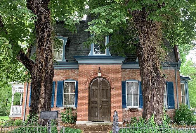 Step into a piece of history with this beautiful Victorian residence, where timeless craftsmanship and architectural detail have been preserved through the years. Framed by two majestic mature trees, the stately brick facade and distinctive mansard roof create an unforgettable first impression. Inside, you're welcomed by a grand foyer featuring an original arched wood entry door with a stained-glass transom, soaring ceilings, rich hardwood floors, and exquisite millwork throughout. Ornate wood trim, decorative moldings, vintage radiators, and period details celebrate the home's historic charm while creating a warm and inviting atmosphere. The main level offers several spacious formal rooms designed for entertaining and everyday living, while all bedrooms and private living quarters are conveniently located on the second floor. A stunning formal dining room showcases solid oak paneled wainscoting, elegant wallpaper, an arched doorway, and a classic chandelier—providing the perfect setting for holiday gatherings, dinner parties, or special occasions. Every room reflects the quality and craftsmanship of a bygone era, offering endless opportunities to restore, preserve, or thoughtfully blend modern updates with timeless design. Outside, the shaded yard provides a peaceful retreat beneath towering mature trees, while the inviting front porch is the perfect place to enjoy your morning coffee or unwind in the evening. Whether you're searching for a distinguished family home, a restoration masterpiece, or a property rich in historic character, this exceptional residence presents a rare opportunity to own a home where original architectural details remain the centerpiece. Buyer to verify all listing information, including but not limited to square footage, room measurements, features, lot size, taxes, exemptions, schools, and all other pertinent details. Schedule a tour with your favorite Realtor today!