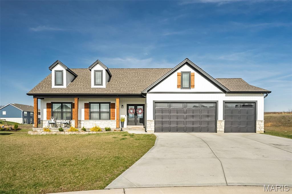 Why wait to build when this beauty is move in ready, beautifully maintained, and full of upgrades? This modern farmhouse stunner is located on one of the largest and more private lots in the subdivision, a full acre! From the moment you arrive, you'll appreciate the curb appeal, with an inviting front porch, board and batten siding, solid cedar posts and shutters, and double front doors with black decorative grid - matching the windows. Inside, from the large entryway, your eyes are immediately drawn to the custom fireplace wall and upgraded lighting everywhere. This home offers a warm and functional layout with tons of builder upgrades like canned lighting in the soffits, an extended garage, rod and spindle staircase, and ceiling fans. The finished basement is a true highlight and an entertainers paradise - featuring an extra bedroom, a stylish bar area, a "hobby" room with a pegboard wall,  and a spacious recreation area! The full bath is framed out and ready to be finished.