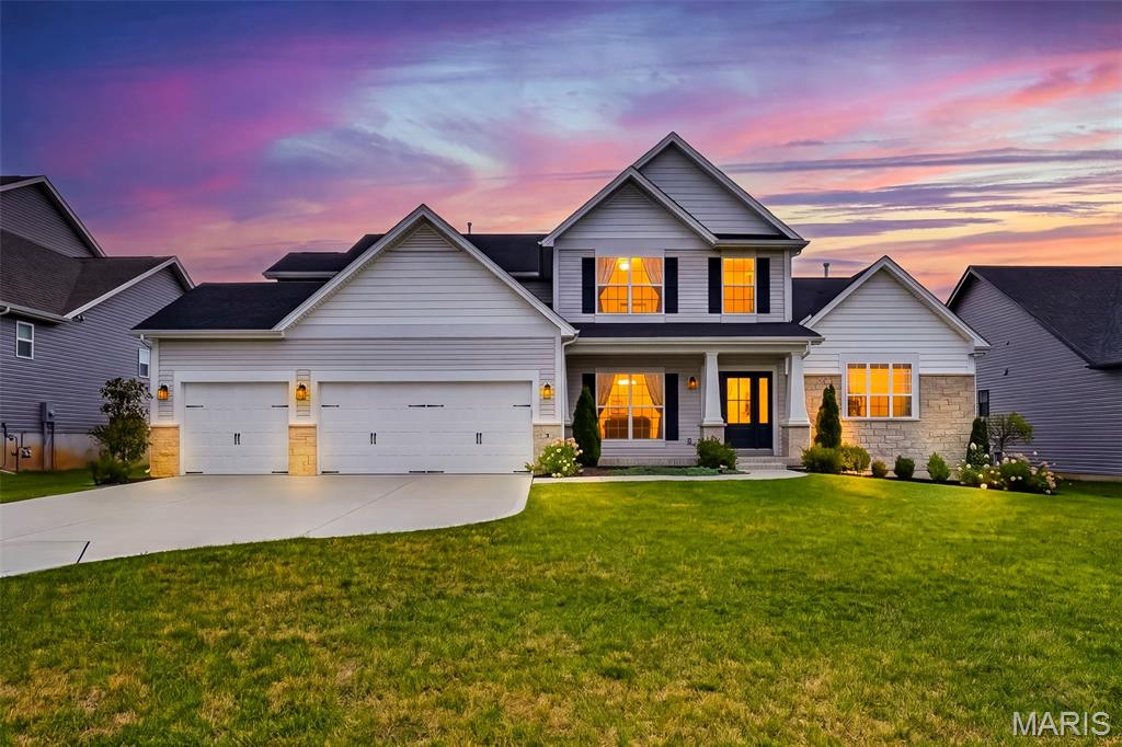 Why build and wait when you can move right into this impeccably maintained, fully upgraded Designer Series Muirfield model? Located at 3 Warchol Court in the prestigious Inverness community and in the highly accredited Wentzville-Liberty school district, this better-than-new, 4 bedroom, 3.5 bathroom, 1.5 story luxury residence with nearly 3,800 sq. ft. offers the rare opportunity to enjoy all the benefits of new construction without the delays, uncertainty, or added expense. Positioned on a quiet cul-de-sac in an established phase of the neighborhood, this pristine three-year-old home includes thousands of dollars in enhancements already completed for you, including professional landscaping, an expansive poured concrete patio, and a multi-zone smart irrigation system—eliminating many of the costly upgrades often encountered after closing on new construction. Thoughtfully designed with both elegance and functionality in mind, the home showcases exceptional craftsmanship and upscale finishes throughout. The stunning great room features soaring 11-foot ceilings, sun-filled transom windows, and stone fireplace, creating a warm yet sophisticated gathering space. At the heart of the home, the gourmet kitchen is beautifully appointed with a professional gas cooktop, stainless vent hood, built-in wall oven, farmhouse sink, under-cabinet lighting, and generous entertaining space that flows seamlessly into the main living areas.
A striking wrought-iron staircase leads to an elevated bonus retreat, offering flexible space ideal for a private office, media room, playroom, or lounge. The luxurious main-level owner's suite serves as a peaceful sanctuary, highlighted by spa-inspired Calacatta-style tile, a deep soaking tub, an oversized walk-in shower with frameless glass enclosure and matte black fixtures, dual vanities, and a spacious walk-in closet. Additional features include programmable climate control, an Aprilaire whole-home humidifier, and an oversized three-car garage. Residents enjoy access to Inverness' exceptional 106-acre master-planned setting featuring scenic lakes, walking trails, pickleball courts, and highly acclaimed Wentzville schools. For golf enthusiasts, Lake Forest Country Club is just a short golf cart ride away, offering private golf and social memberships, along with seasonal pool and pickleball access. Skip the construction delays, builder markups, and disruption of ongoing development. This luxury home offers the convenience of immediate enjoyment, the value of completed upgrades, and the lifestyle you've been waiting for.