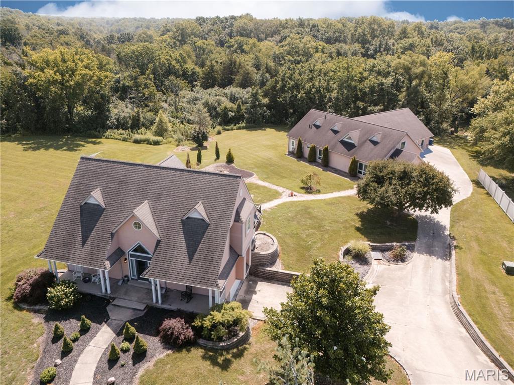 Situated on approximately two acres in a private lake community offering fishing and boating, this unique home provides approximately 2,388 square feet of living space along with a 4,700-square-foot guest house and storage building.

The main home features 3 bedrooms, 2.5 bathrooms, a beautiful kitchen, dining area, sitting room, a living room with a fireplace, and option for main floor or basement laundry. A 470-square-foot deck overlooks the private backyard with firepit area and backs to wooded area, creating a comfortable space for outdoor enjoyment.

The guest house includes a full kitchen, open dining and living room area, bedroom, and two full bathrooms, making it ideal for guests, extended family, or flexible living arrangements. Additional features include a mirrored exercise room, large bar, theatre seats for movie area, and multiple flex rooms for additional storage, office space, craft rooms, non-conforming bedrooms, playrooms, etc. Geothermal heating in the main home, propane heat in the guest house/storage building, and an attached one-car garage. This property is situated on 2 parcels.
