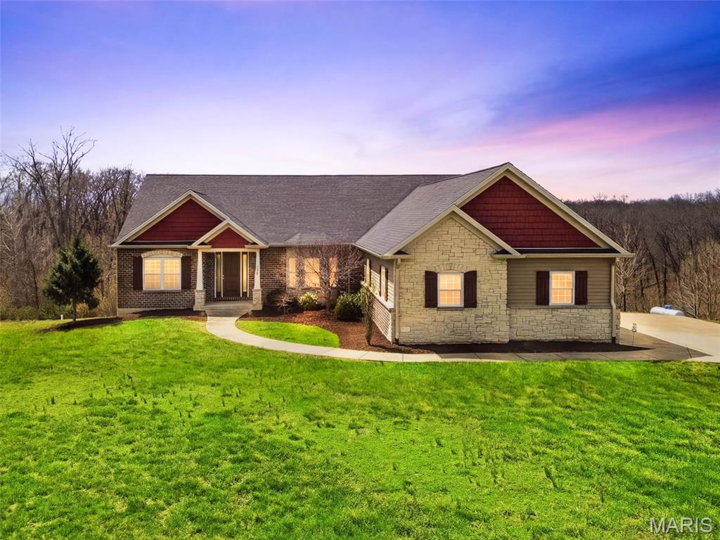 Back active due to no fault of the seller. Welcome to this massive and luxurious Ranch home with beautiful 3/4" Hickory hardwood throughout the main floor living home. Massive laundry room off of the garage is accessible by a ramp. This house is wired with Spectrum fiber internet for trusted internet at all times. Incidental lighting behind crown molding in the Great Rm and the Primary Bedroom give excellent lighting options. LAN lines have been ran to the Office, Primary Bedroom and 2 in Great Rm. House has Origin Speaker system installed, for covered deck, Great Rm, (2) Great Rm (3) Primary BR, and 1 in Primary Bath. Great Rm is wired for surround sound. HEOS system in basement with remote runs the whole house. Basement is walk out with a massive, covered patio.  The Great Rm is open to the Kitchen and Breakfast Rm, separated by HUGE semi-octagonal double tiered Center Island with electric. The Breakfast Rm and Great Rm walk out to the covered deck with speakers in ceiling and see through fireplace. Granite counter tops, gas cooktop with vent, wall oven and microwave is a cooks dream. Regardless if you cook or not you will LOVE this beautiful home with private Office. Beauty is everywhere. The garage has an 8ft. door. The giant oversized front wood door welcomes you to this magical home. Basement has a HUGE work bench area, is a walk out and waiting for your finishes. The view is breathtaking. All of this and so much more including solar panels on roof electric bill is approx. $100 p/m in winter and no bill April through November plus Ameren buys back what you don't use! 12 ft veins and 8ft interior doors make this house very Grand!