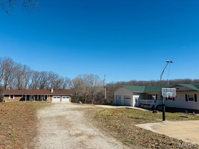 Welcome to a once-in-a-lifetime opportunity! If you have been searching for a property that truly has it all (space, privacy, versatility, income potential, and move in ready comfort) your search ends here! Nestled on a breathtaking 19.7 acres in Crawford County, this remarkable estate offers not one, but TWO BEAUTIFUL HOMES, MULTIPLE outbuildings, an event ready garage, and wide open land ready to support whatever vision you have for your future. Properties like this are exceptionally rare, and the opportunities it presents are as expansive as the land itself. Whether you are dreaming of multi-generational living, generating rental or Airbnb income, creating a private retreat, establishing a small homestead, or simply enjoying peaceful country life with room to roam, this property checks every box and then some. The first home is a 3 bedroom, 3 bath home that blends comfort, functionality, and thoughtful design. This warm and cozy home is ideal for a full time residence, offering ample space for family living, entertainment, and everyday enjoyment. This beauty has a new roof, 2 car attached garage, and new siding will be installed before closing! You will be in awe of the gorgeous floors, tasteful paint colors throughout the home, and how sparkling clean and inviting the home is. One of the standout features of this home is the secluded and spacious primary suite located in the finished basement. This private retreat offers a peaceful escape from the rest of the home and is steps away from the bonus family/entertainment room with a gas fireplace! The second home on the property is a beautiful well maintained all brick residence featuring 2 bedrooms and 2 baths. Completely move in ready, this home is perfect for extended family, guests, or rental use. The timeless brick exterior not only adds curb appeal, but also offers durability and low maintenance. A couple of highlights of this home is a new roof and the brand new composite deck on the back designed for longevity for lasting enjoyment.  The deck overlooks the gorgeous property, offering a serene connection to the land and landscape. It not only has a 2 car attached garage, but also an additional detached garage in the backyard! The land itself is truly something special. Spread across 19+ acres, the property offers a mix of mature trees and open fields (fencing on 3 sides), creating a landscape that is both beautiful and functional. No country property is complete without the right outbuildings, and this one delivers. The property includes a huge newer barn, perfect for storing your tractor, equipment, or supplies! Whether you are maintaining the land, farming, or simply need extra storage, this barn adds both convenience and value. One of the most unique and exciting features of this property is the event garage, a fully equipped space designed for entertaining, gathering, and celebrating. This space has a full kitchen (stove, sink, and fridge) with a large gathering area (seating included) perfect for deer camp, a fish fry, family reunions, holiday celebrations, birthday parties, and so much more! If you love hosting friends and family this building is an absolute standout! This truly is a once in a lifetime opportunity and it won't last long! With two homes, 19+ acres, multiple outbuildings, and endless potential, this property offers unmatched value and flexibility. Schedule your private showing today and come experience firsthand everything this incredible property has to offer. Once you see it, you will understand this is more than a place to live. It's a place to live well.