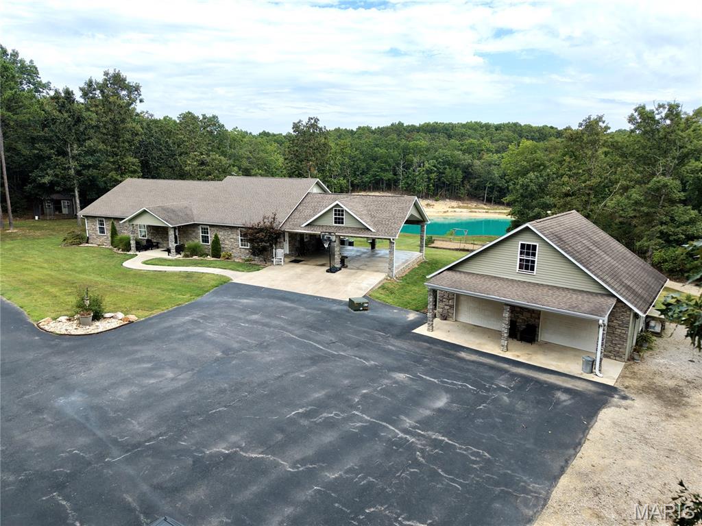 Discover a truly exceptional custom-built estate where luxury, craftsmanship, and peaceful country living come together. Offering nearly 5,000 square feet of thoughtfully designed living space, this remarkable 6-bedroom, 5-bath home is one to behold. From the unique wood floors, to the large walk in showers. Surrounded by incredible views and breathtaking scenery, the property offers the privacy and tranquility you've always dreamed of.
The exterior showcases timeless brick and natural stone, creating an inviting presence that perfectly complements the beautifully landscaped grounds. Inside and out, quality craftsmanship is evident throughout. A custom workshop adds even more appeal, thoughtfully crafted with rich wood and rustic metal accents perfect for projects, hobbies, or additional workspace.

Step outside to enjoy the expansive yard and a large, stocked pond featuring sandy banks and electricity at the swimming dock, creating an ideal setting for relaxing, entertaining, fishing, or enjoying summer days by the water. The oversized circular drive provides an impressive arrival and plenty of parking for guests.

With sweeping views, lush landscaping, unmatched privacy, and exceptional custom details, this property offers a rare combination of comfort, character, and natural beauty. A one-of-a-kind retreat ready to be enjoyed for years to come.