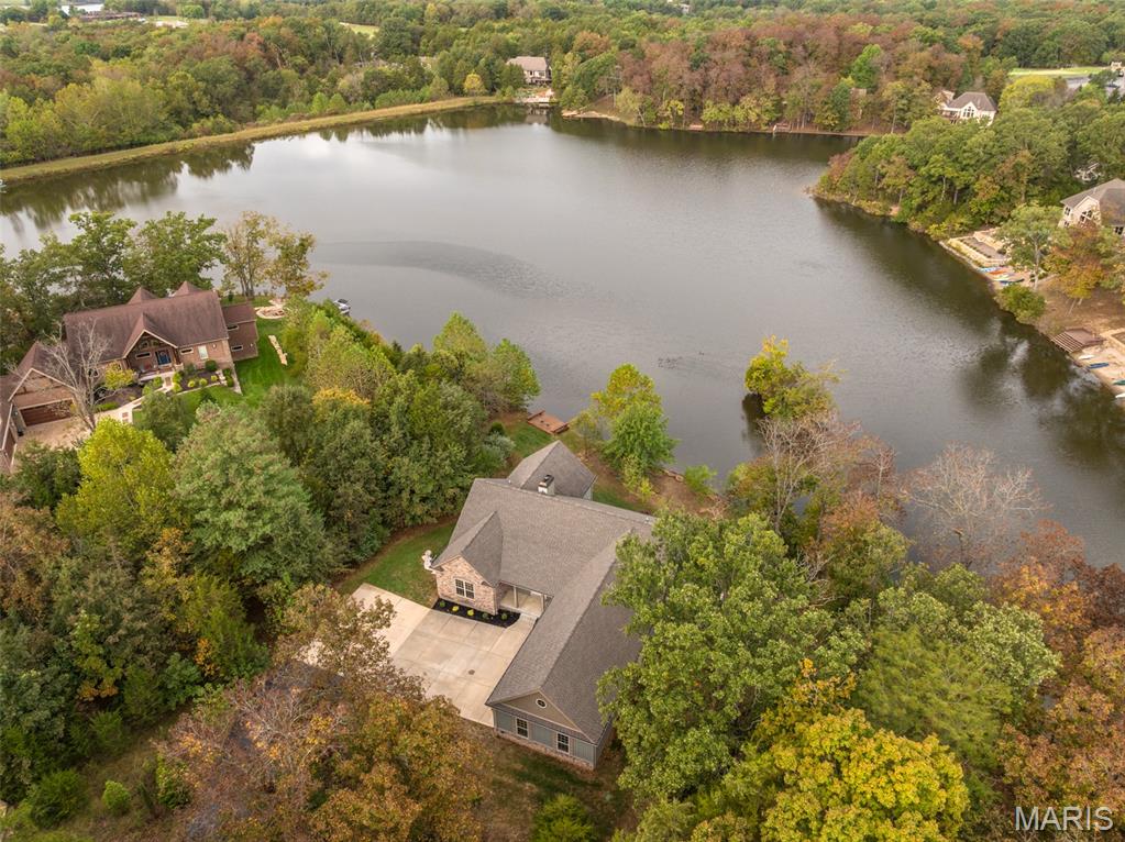 Additional Photos Coming Soon.  Landscaping updates and view enhancements to be completed shortly.
Adorable Lakeside Cottage 
Perfectly positioned on the tranquil shores of Charrette Lake, this impeccably designed cottage-style retreat offers the finest in lakeside living. With over 170 feet of pristine shoreline and sweeping water views, this exceptional property seamlessly blends timeless charm with modern luxury.
The home features five well-appointed bedrooms, plus a spacious bonus room with captivating lake views — ideal for a fitness studio, additional guest quarters, or an elevated bunk room.
At the heart of the home is a gourmet kitchen curated for the discerning chef, featuring bespoke custom cabinetry, premium appliances, and an expansive walk-in pantry. The kitchen opens to a dramatic great room, where a floor-to-ceiling stone fireplace and a striking wall of windows frame panoramic lake views and flood the space with natural light.
Step out onto the covered screen porch, complete with a second stone fireplace — the perfect year-round space for outdoor dining or relaxing by the fire. A gentle slope leads down to the water’s edge, offering effortless lake access and an idyllic setting for lakeside enjoyment.  Additional highlights include an expanded finished three-car garage ideal for storing lake toys, vehicles, golf carts.
This extraordinary property is a rare blend of elegance, comfort, and natural beauty — a true sanctuary on the shores of Charrette Lake.